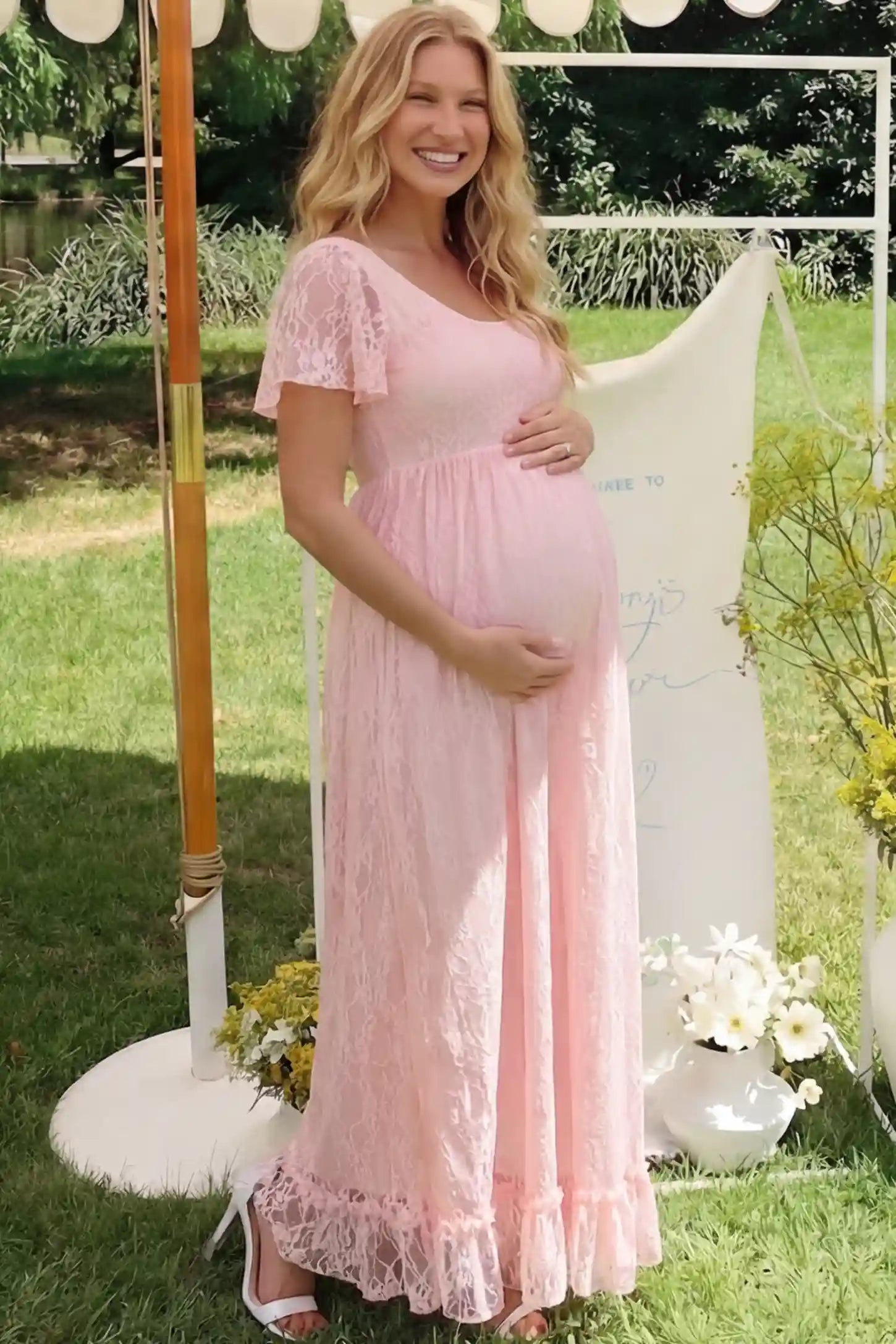 Floral Lace Flutter Sleeve Maxi Maternity Dress in Pink featuring delicate lace and an empire waist on a pregnant model.