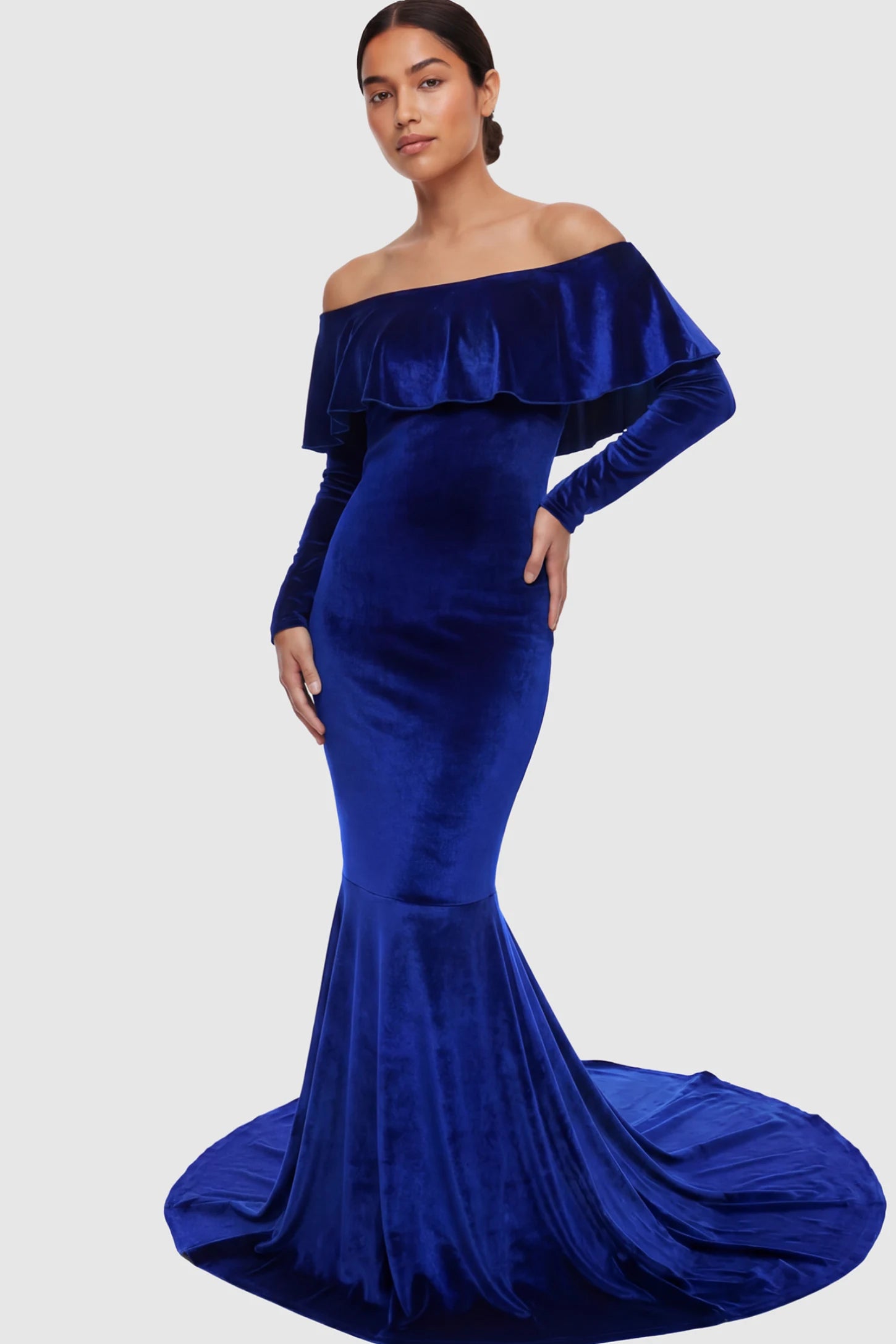 Velvet Off Shoulder Long Sleeve Maternity Mermaid Gown Velvet Off-the-Shoulder Maternity Mermaid Gown in rainbow blue featuring a ruffled neckline and long sleeves on a model.