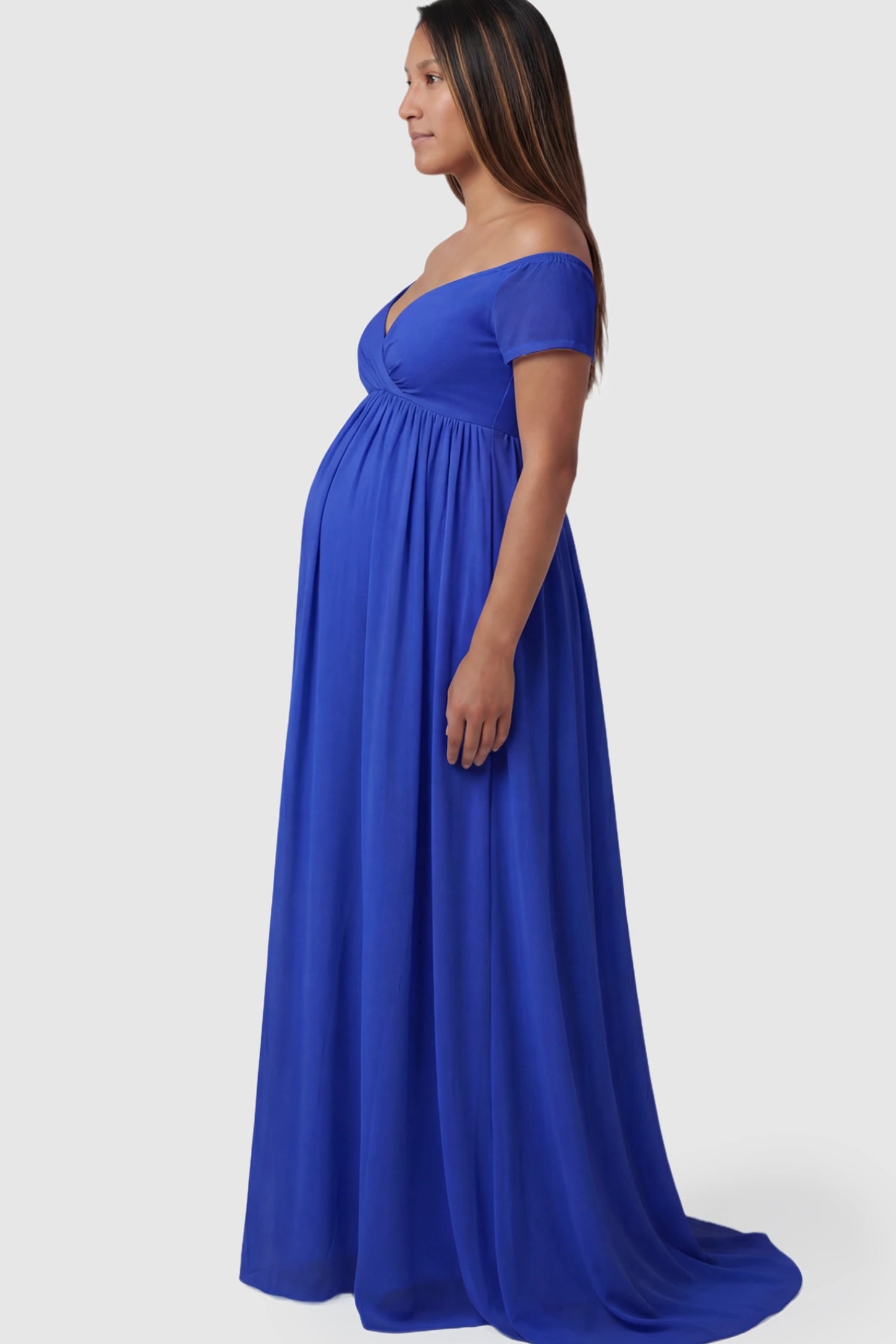 Solid Off Shoulder Flowy Maternity Maxi Dress Solid Off-the-Shoulder Sweetheart Maternity Maxi Dress in Dark Blue featuring an empire waist on a pregnant model.