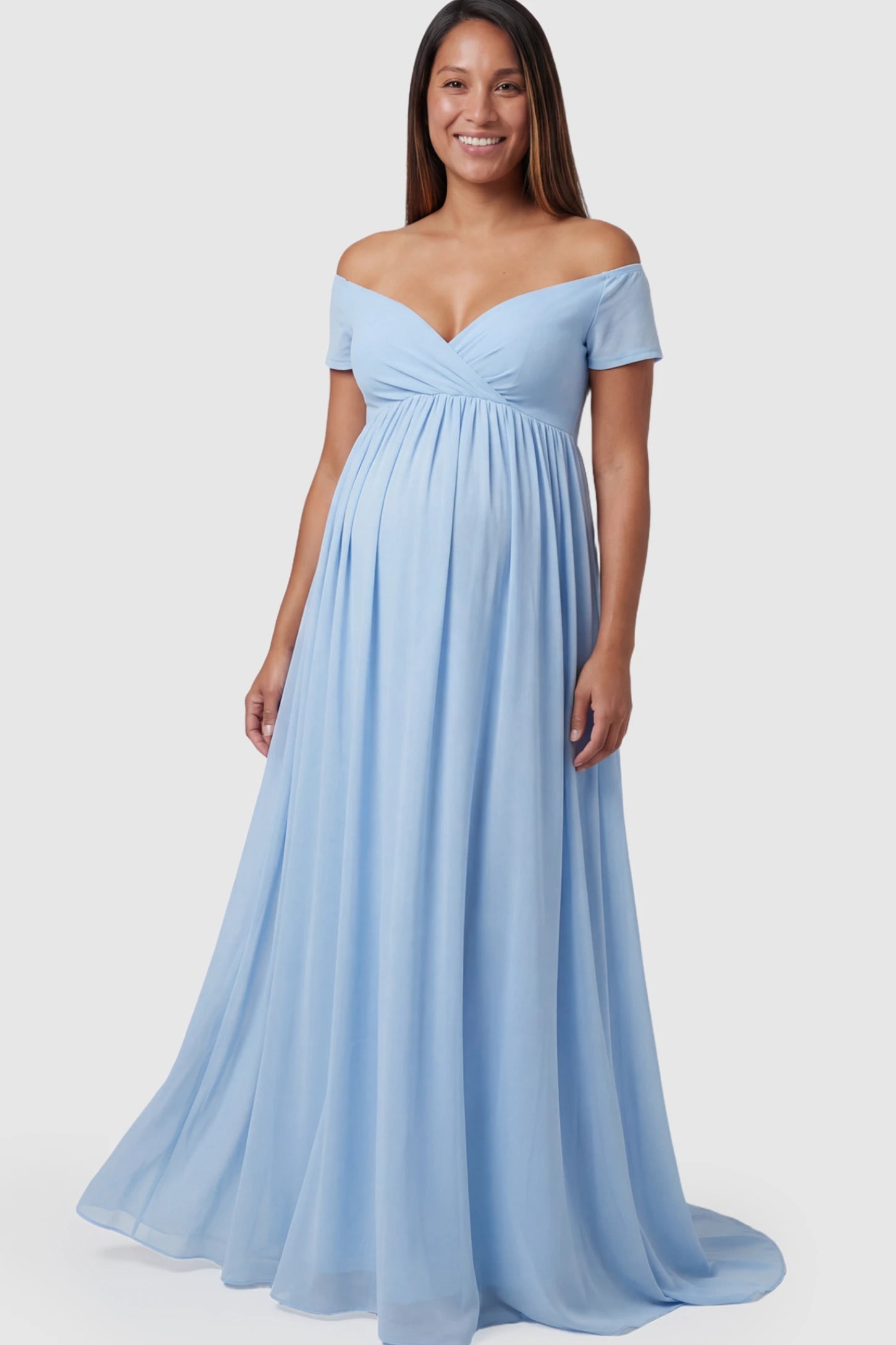 Solid Off Shoulder Flowy Maternity Maxi Dress Solid Off-the-Shoulder Sweetheart Maternity Maxi Dress in Light Blue featuring an empire waist on a pregnant model.