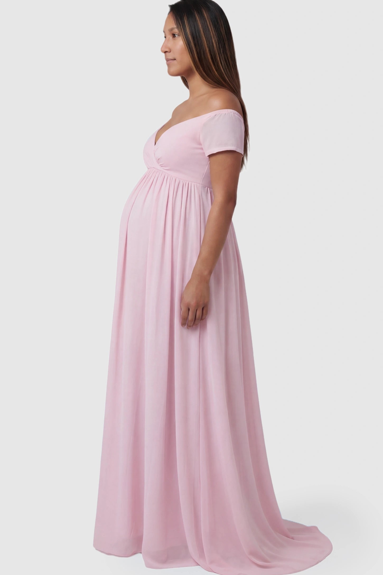 Solid Off Shoulder Flowy Maternity Maxi Dress Solid Off-the-Shoulder Sweetheart Maternity Maxi Dress in Pink featuring an empire waist on a pregnant model.