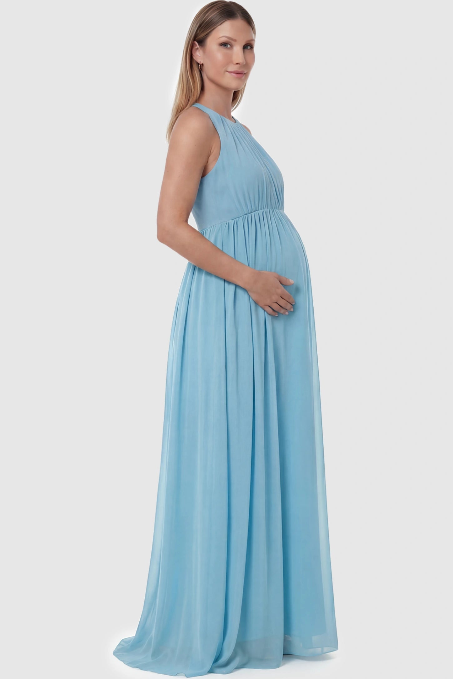 Pleated Mesh Sleeveless Maternity Photoshoot Dress Pleated Mesh Sleeveless Maternity Maxi Dress in light blue with an empire waist on a pregnant model.