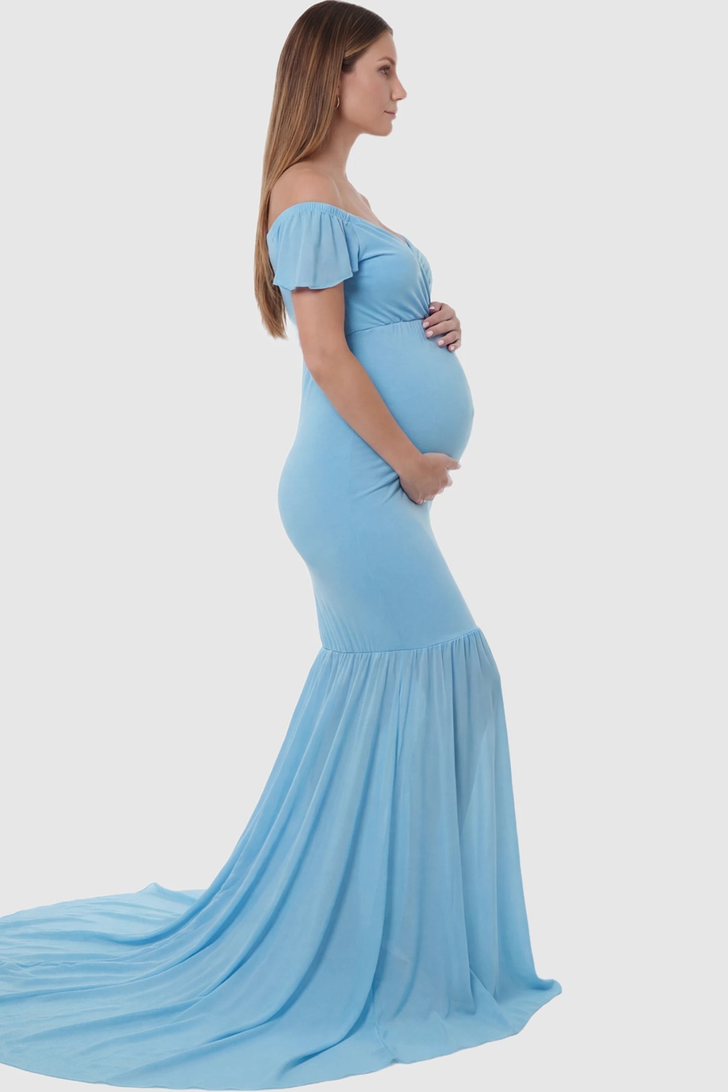 Solid Off Shoulder Fitted Maternity Photoshoot Gown Solid Off Shoulder Fitted Maternity Photoshoot Gown in light blue featuring a sweetheart cross-front bodice and flowing chiffon train on a pregnant model.