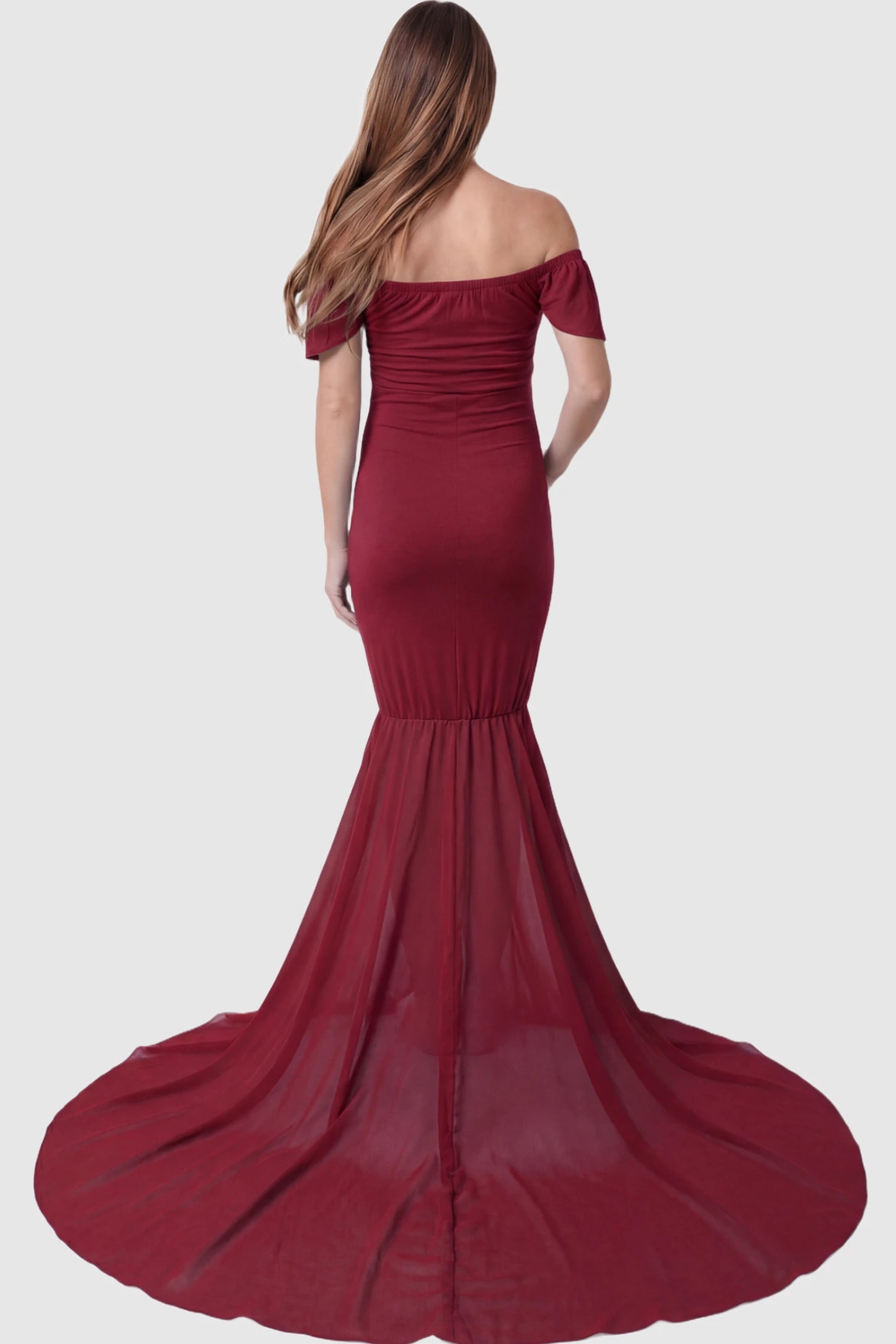Solid Off Shoulder Fitted Maternity Photoshoot Gown Solid Off Shoulder Fitted Maternity Photoshoot Gown in red featuring flowing chiffon train on a pregnant model.