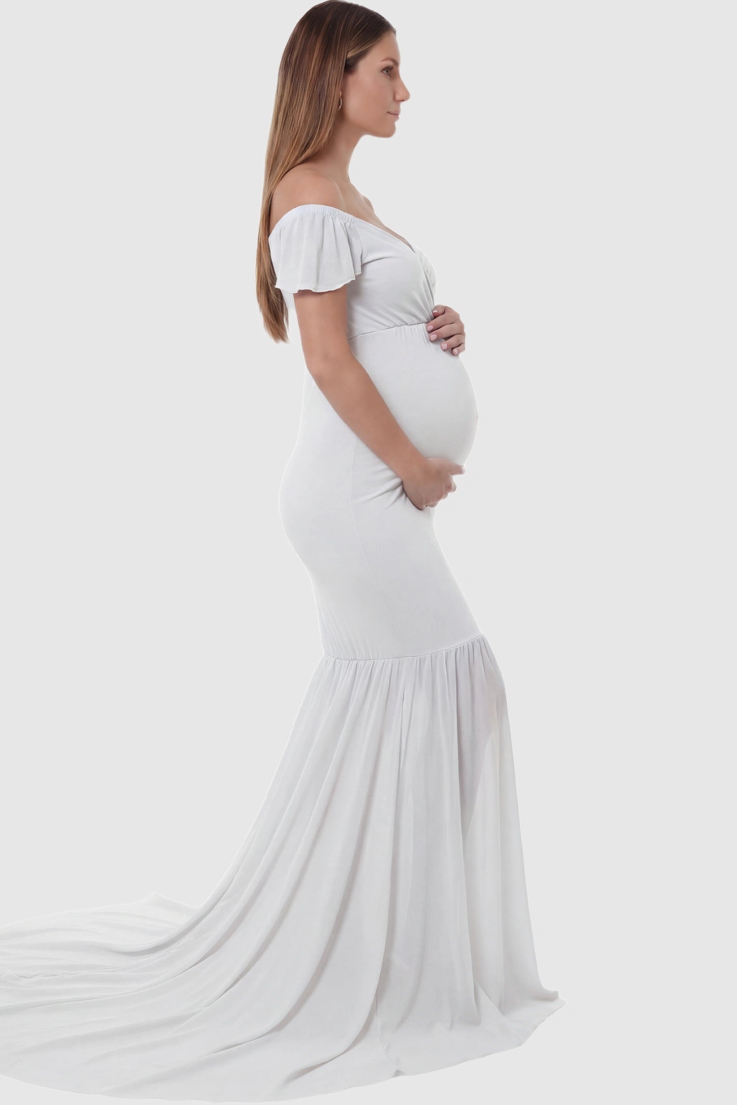 Solid Off Shoulder Fitted Maternity Photoshoot Gown Solid Off Shoulder Fitted Maternity Photoshoot Gown in white featuring a sweetheart cross-front bodice and flowing chiffon train on a pregnant model.