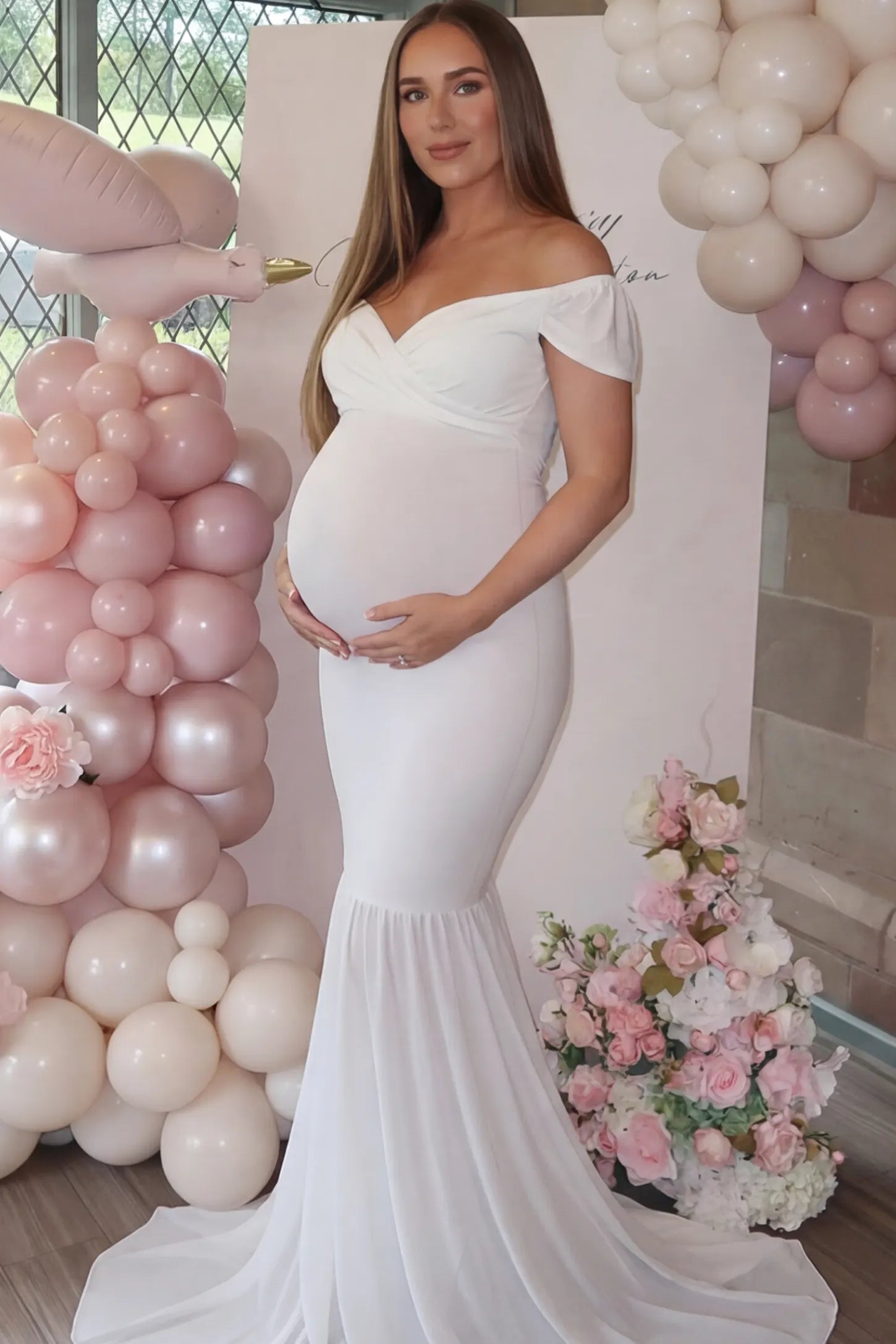 Solid Off Shoulder Fitted Maternity Photoshoot Gown Solid Off Shoulder Fitted Maternity Photoshoot Gown in white featuring a sweetheart cross-front bodice and flowing chiffon train on a pregnant model.
