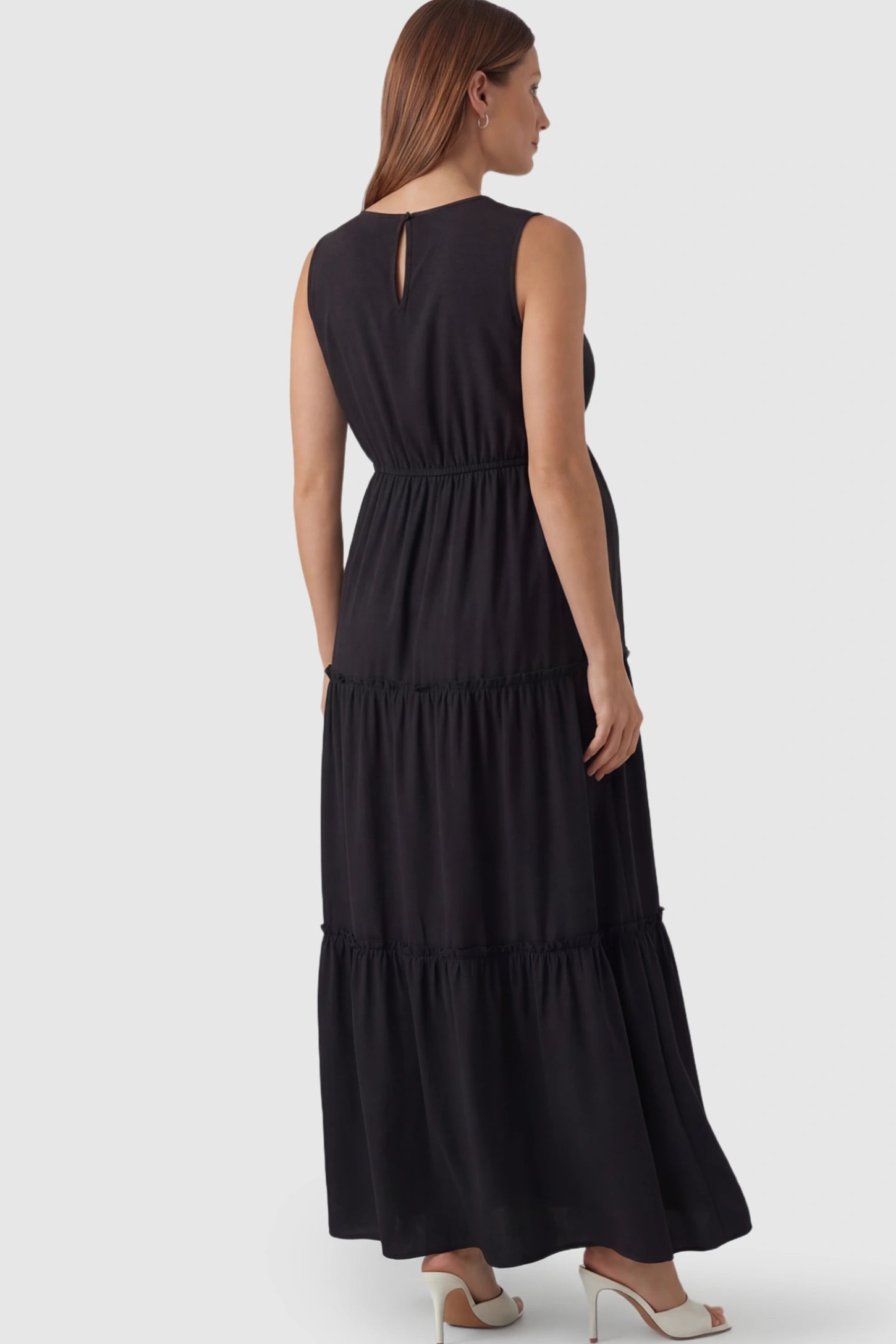 Solid Sleeveless Ruffle Tiered Maternity Midi Dress Solid Sleeveless Ruffle Tiered Maternity Midi Dress in Black featuring a ruffle tiered skirt on a pregnant model.