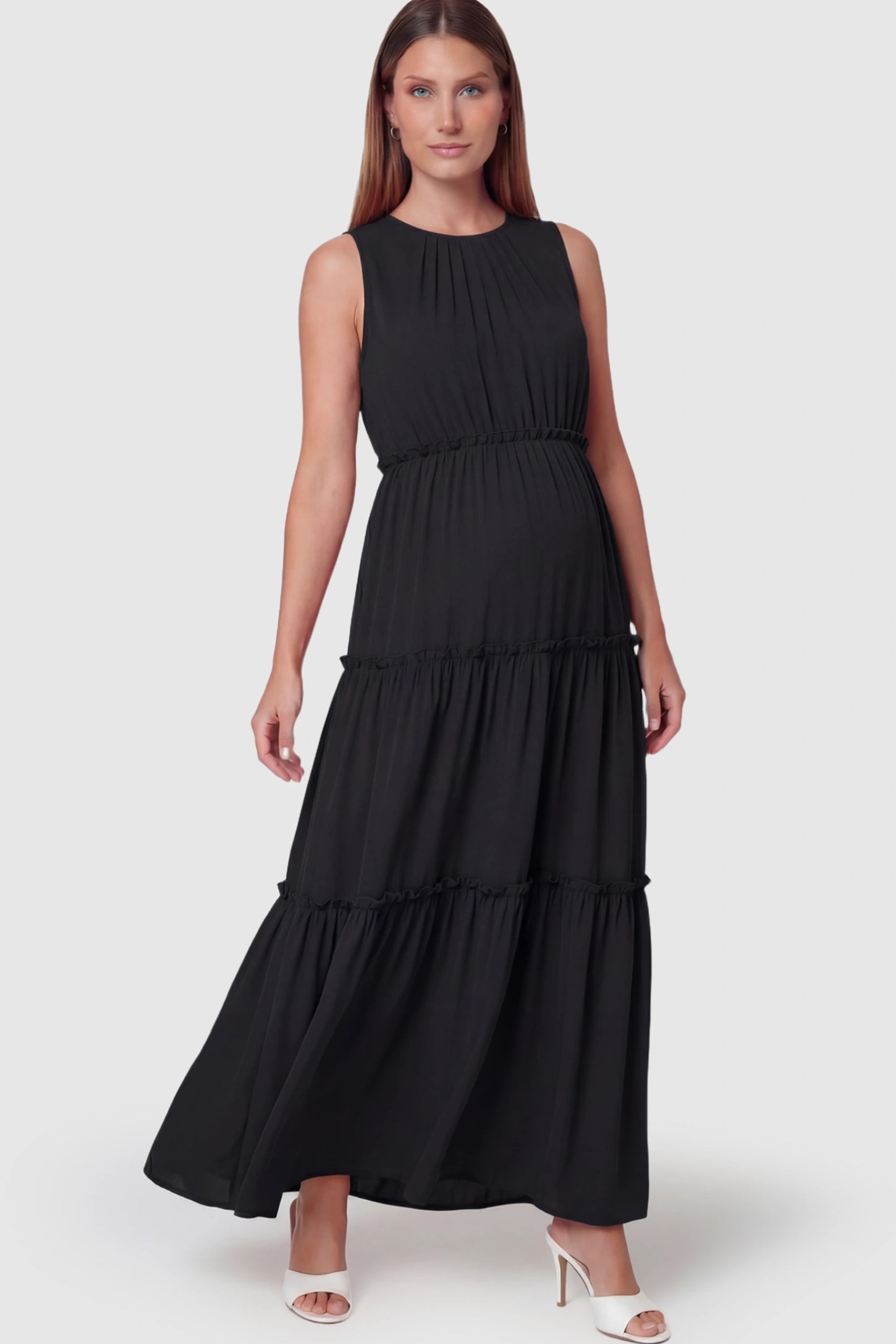 Solid Sleeveless Ruffle Tiered Maternity Midi Dress Solid Sleeveless Ruffle Tiered Maternity Midi Dress in Black featuring a ruffle tiered skirt on a pregnant model.
