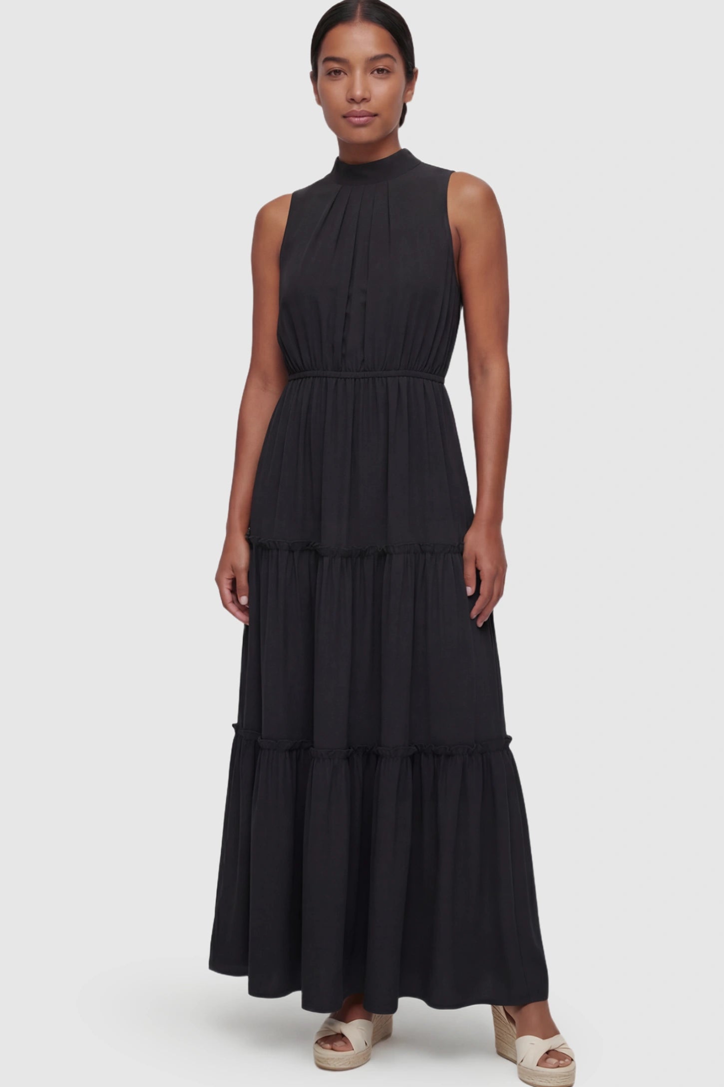 Solid Sleeveless Ruffle Tiered Maternity Midi Dress Solid Sleeveless Ruffle Tiered Maternity Midi Dress in Black featuring a ruffle tiered skirt on a postpartum model.