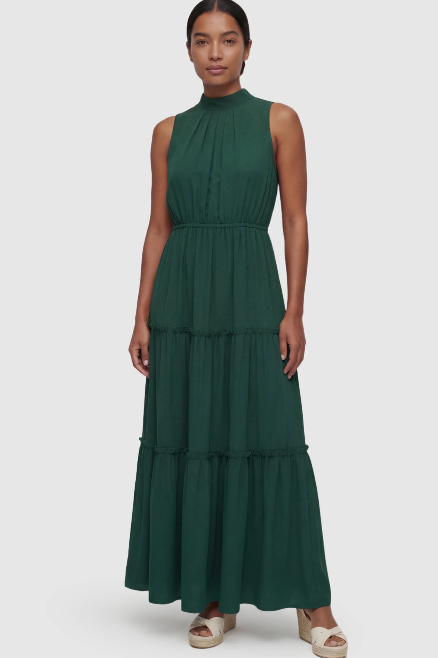 Solid Sleeveless Ruffle Tiered Maternity Midi Dress Solid Sleeveless Ruffle Tiered Maternity Midi Dress in Dark Green featuring a ruffle tiered skirt on a postpartum model.