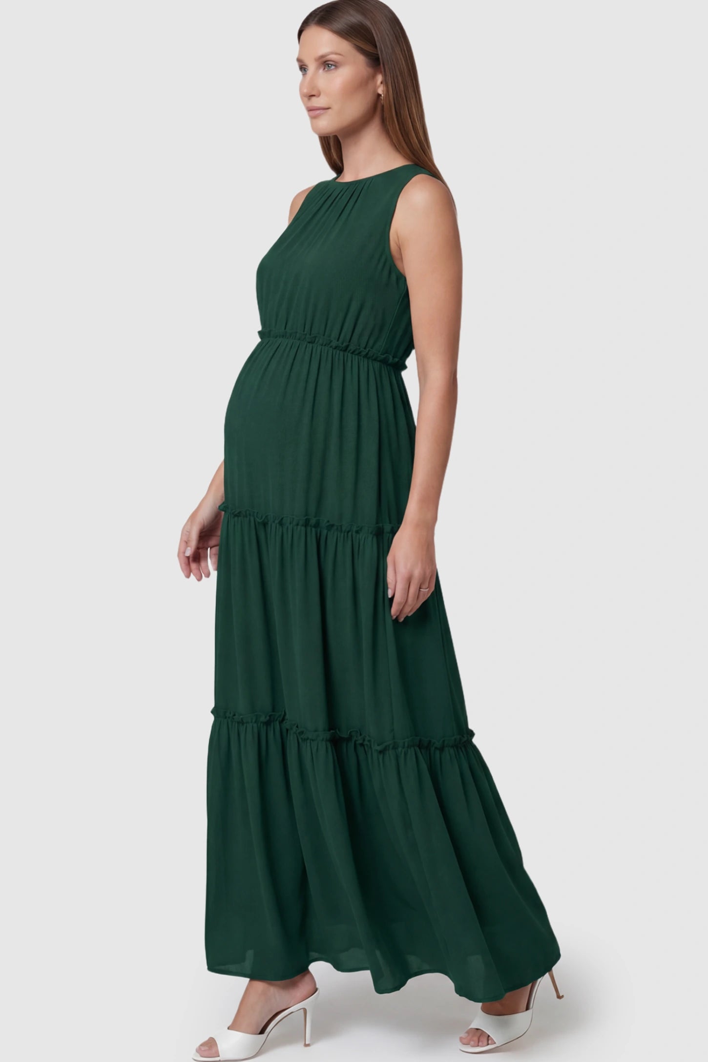 Solid Sleeveless Ruffle Tiered Maternity Midi Dress Solid Sleeveless Ruffle Tiered Maternity Midi Dress in Dark Green featuring a ruffle tiered skirt on a pregnant model.