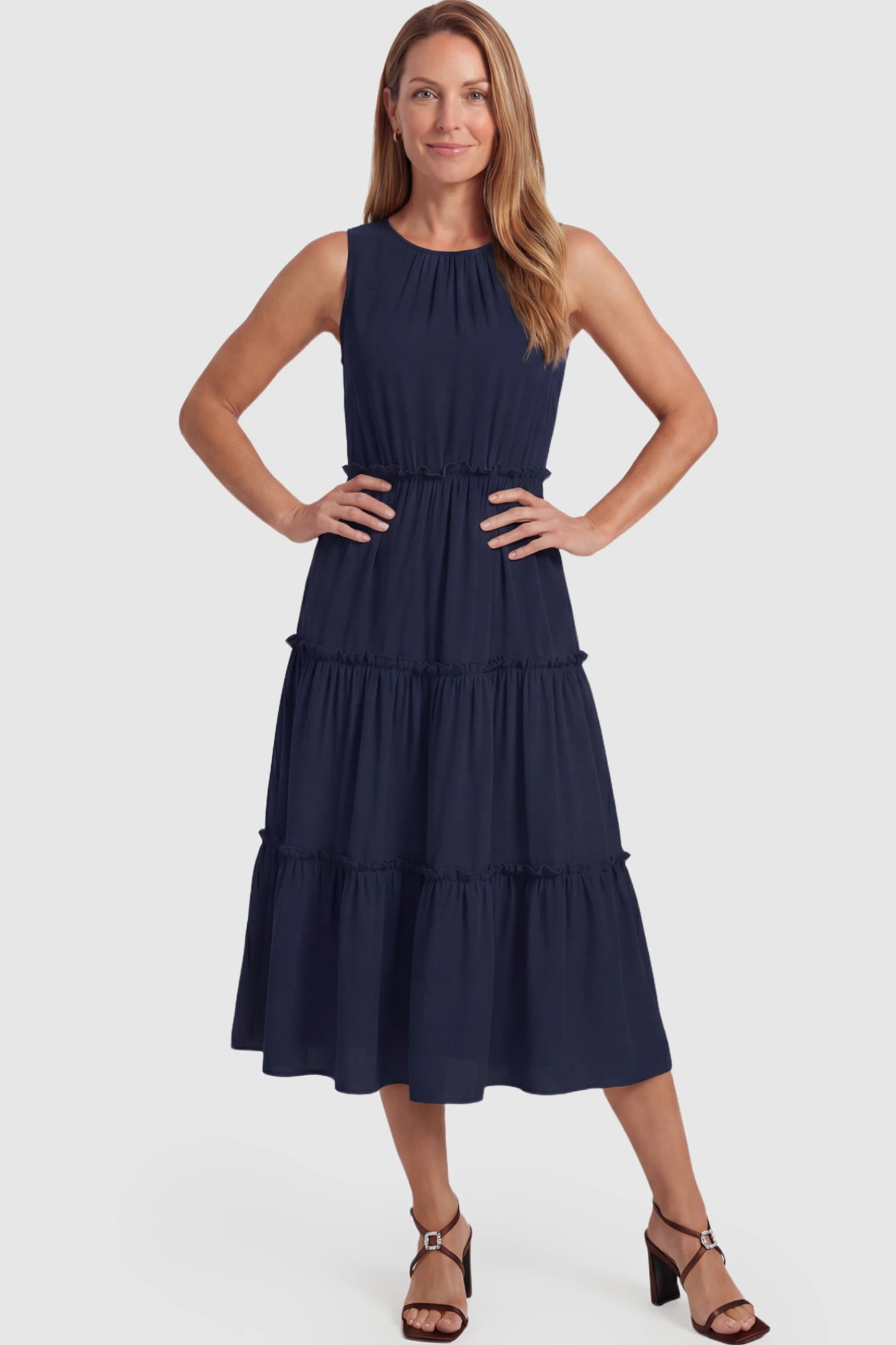 Solid Sleeveless Ruffle Tiered Maternity Midi Dress Solid Sleeveless Ruffle Tiered Maternity Midi Dress in navy blue featuring a ruffle tiered skirt on a postpartum model.
