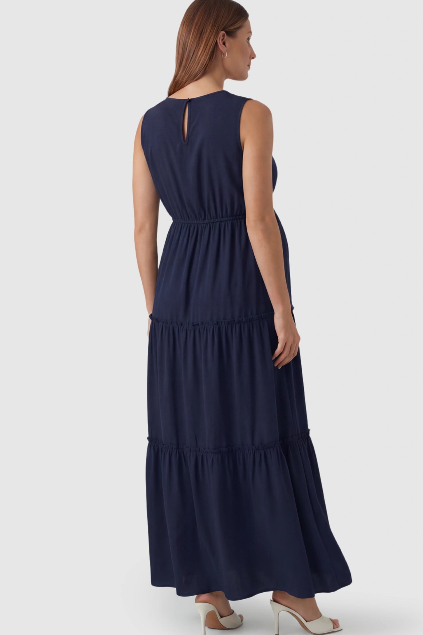 Solid Sleeveless Ruffle Tiered Maternity Midi Dress Solid Sleeveless Ruffle Tiered Maternity Midi Dress in Navy Blue featuring a ruffle tiered skirt on a pregnant model.
