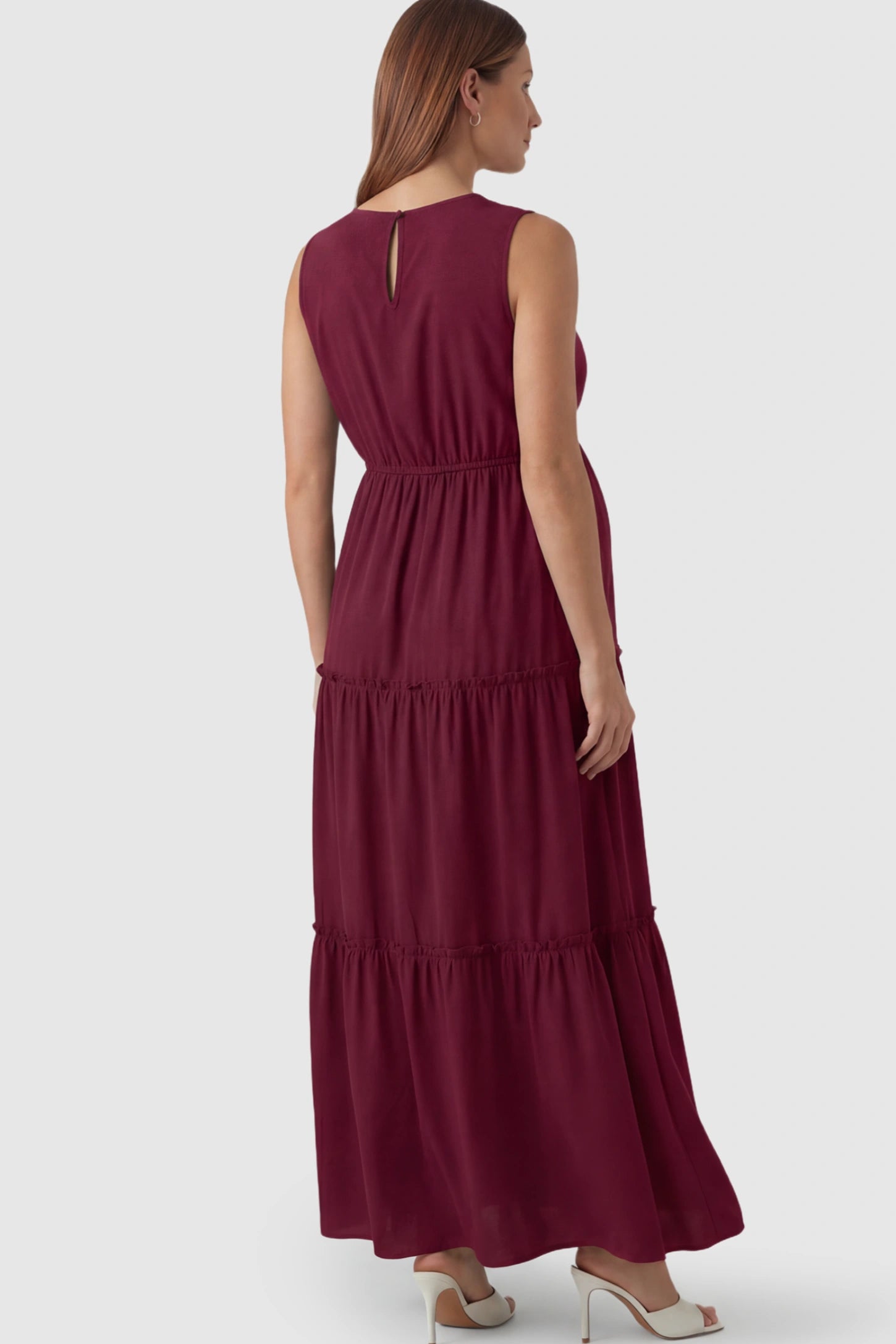 Solid Sleeveless Ruffle Tiered Maternity Midi Dress Solid Sleeveless Ruffle Tiered Maternity Midi Dress in Wine Red featuring a ruffle tiered skirt on a pregnant model.