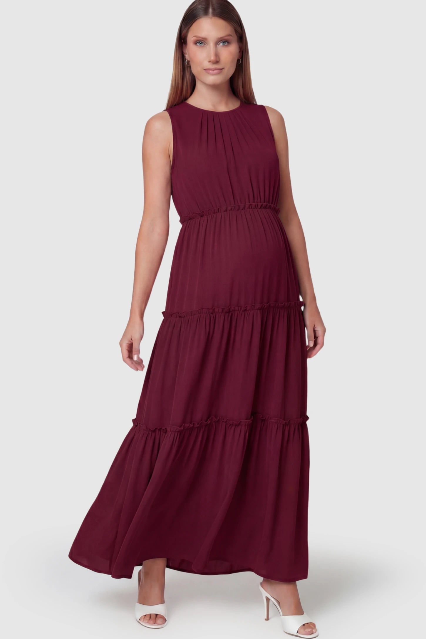 Solid Sleeveless Ruffle Tiered Maternity Midi Dress Solid Sleeveless Ruffle Tiered Maternity Midi Dress in Wine Red featuring a ruffle tiered skirt on a pregnant model.