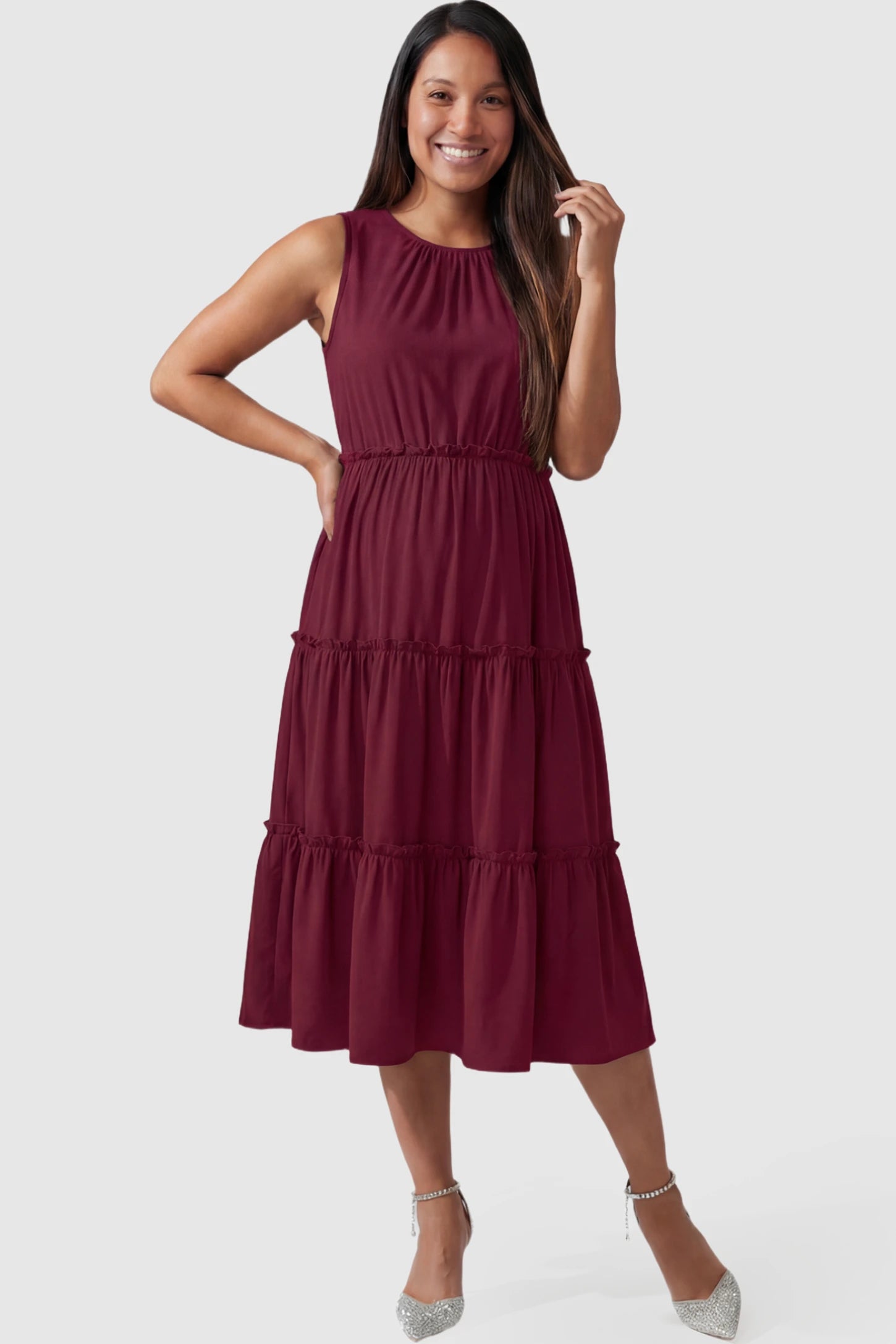 Solid Sleeveless Ruffle Tiered Maternity Midi Dress Solid Sleeveless Ruffle Tiered Maternity Midi Dress in wine red featuring a ruffle tiered skirt on a pregnant model.