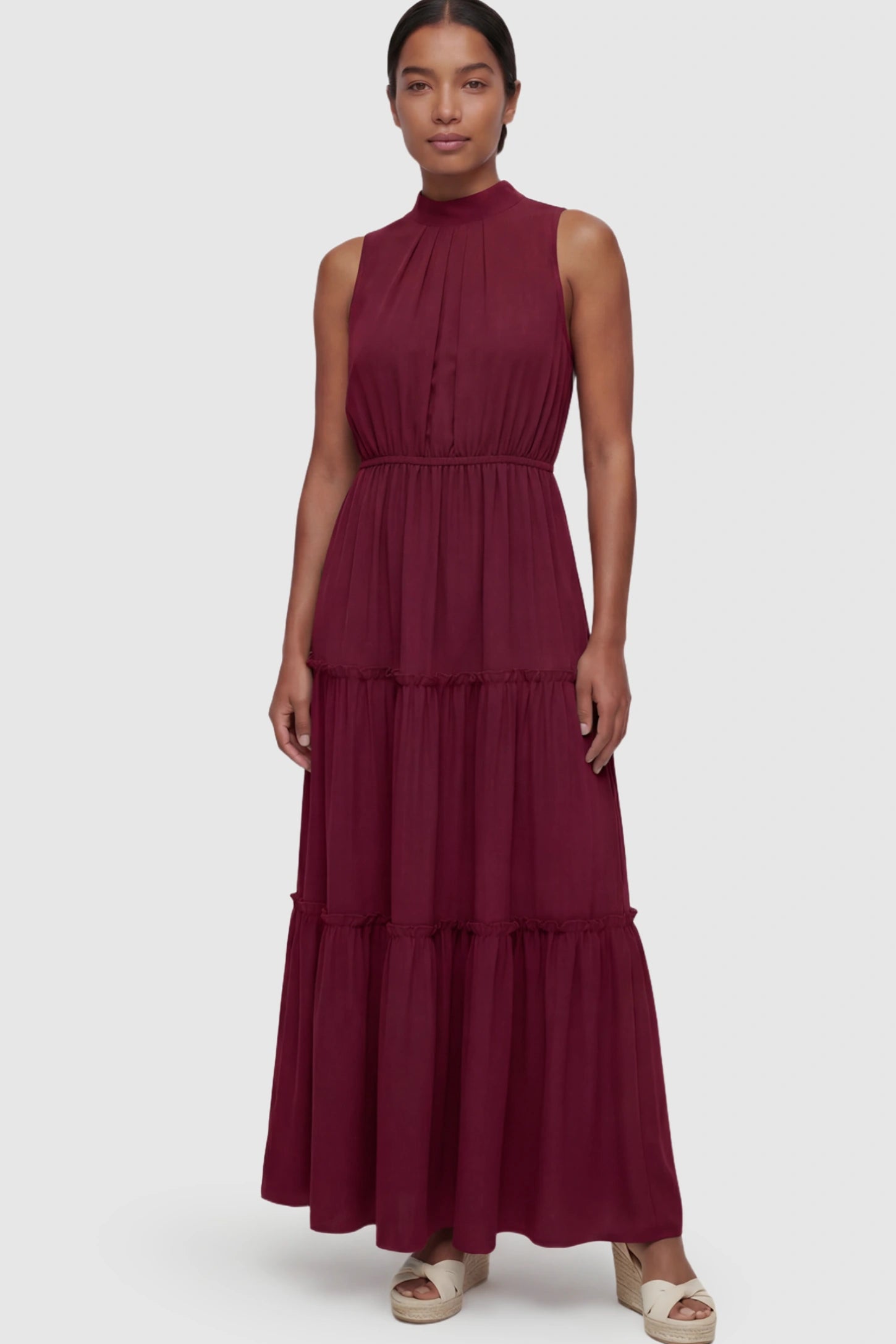 Solid Sleeveless Ruffle Tiered Maternity Midi Dress Solid Sleeveless Ruffle Tiered Maternity Midi Dress in Wine Red featuring a ruffle tiered skirt on a postpartum model.