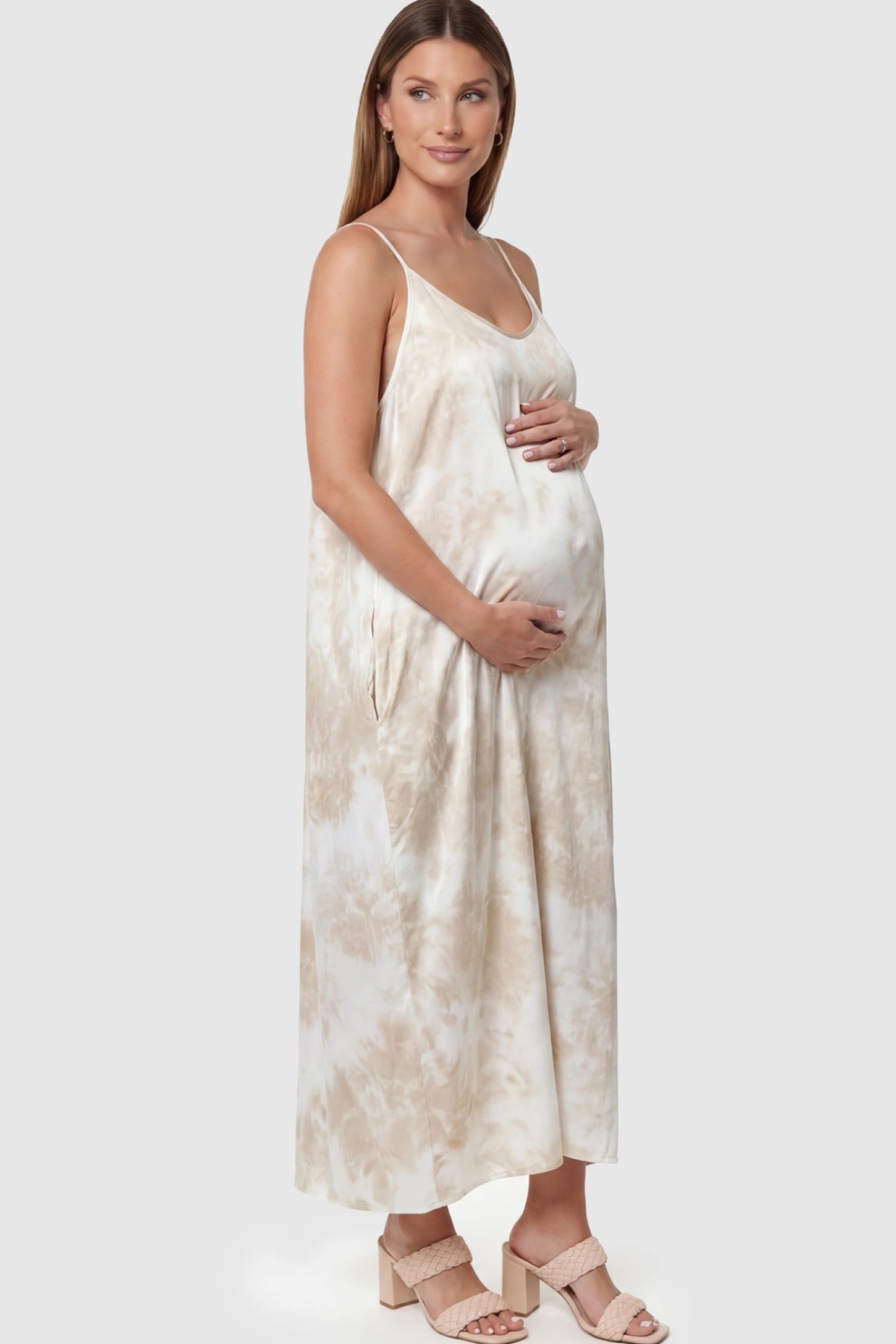 Tie-Dye Print Spaghetti Strap Maternity Maxi Dress Tie-Dye Print Spaghetti Strap Maternity Maxi Dress in Cream and White featuring side pockets on a pregnant model.
