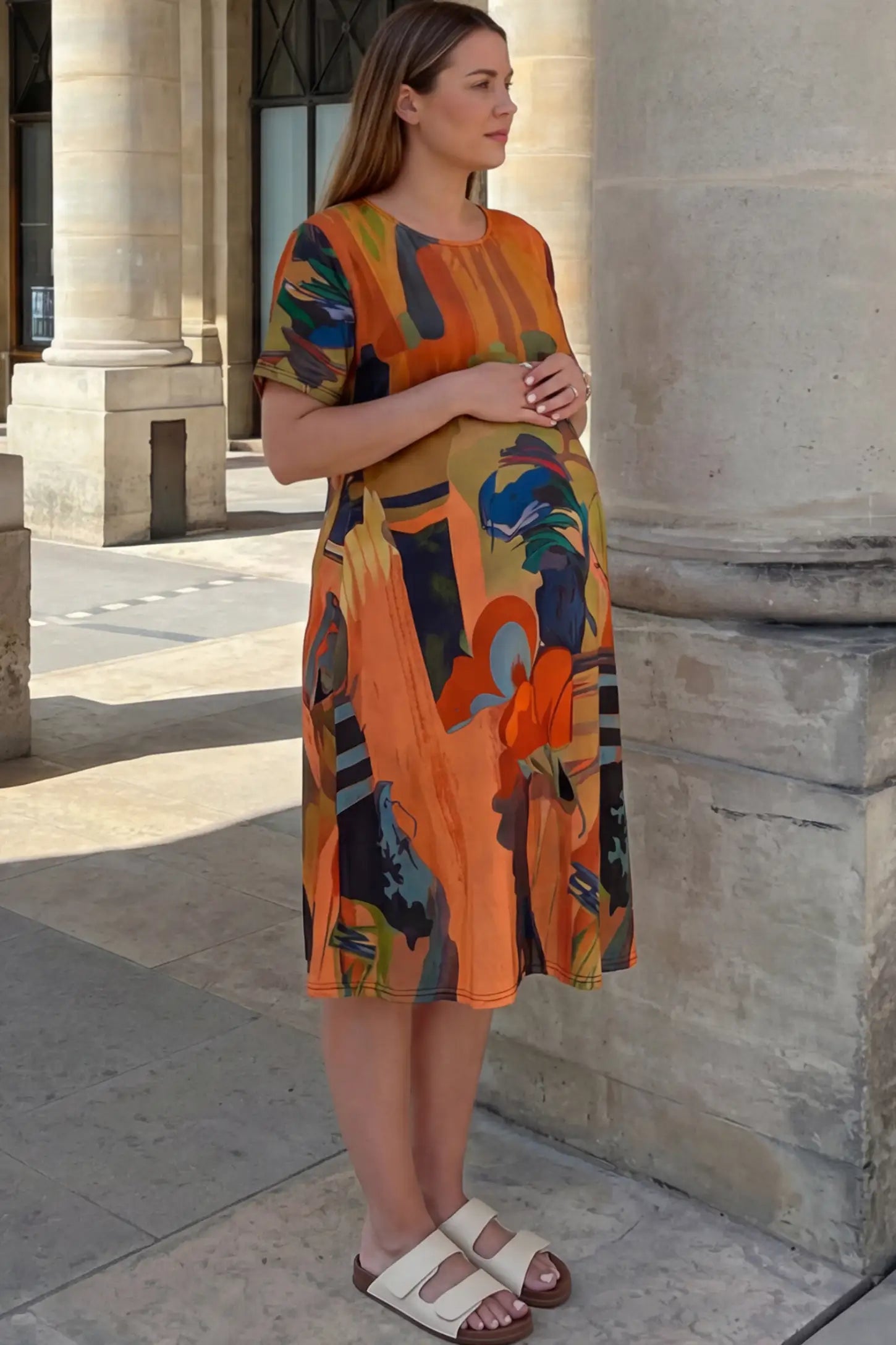 Abstract Print Scoop Neck Maternity Midi Dress Abstract Print Scoop Neck Maternity Midi Dress in vibrant orange featuring a flowy A-line silhouette on a pregnant model.