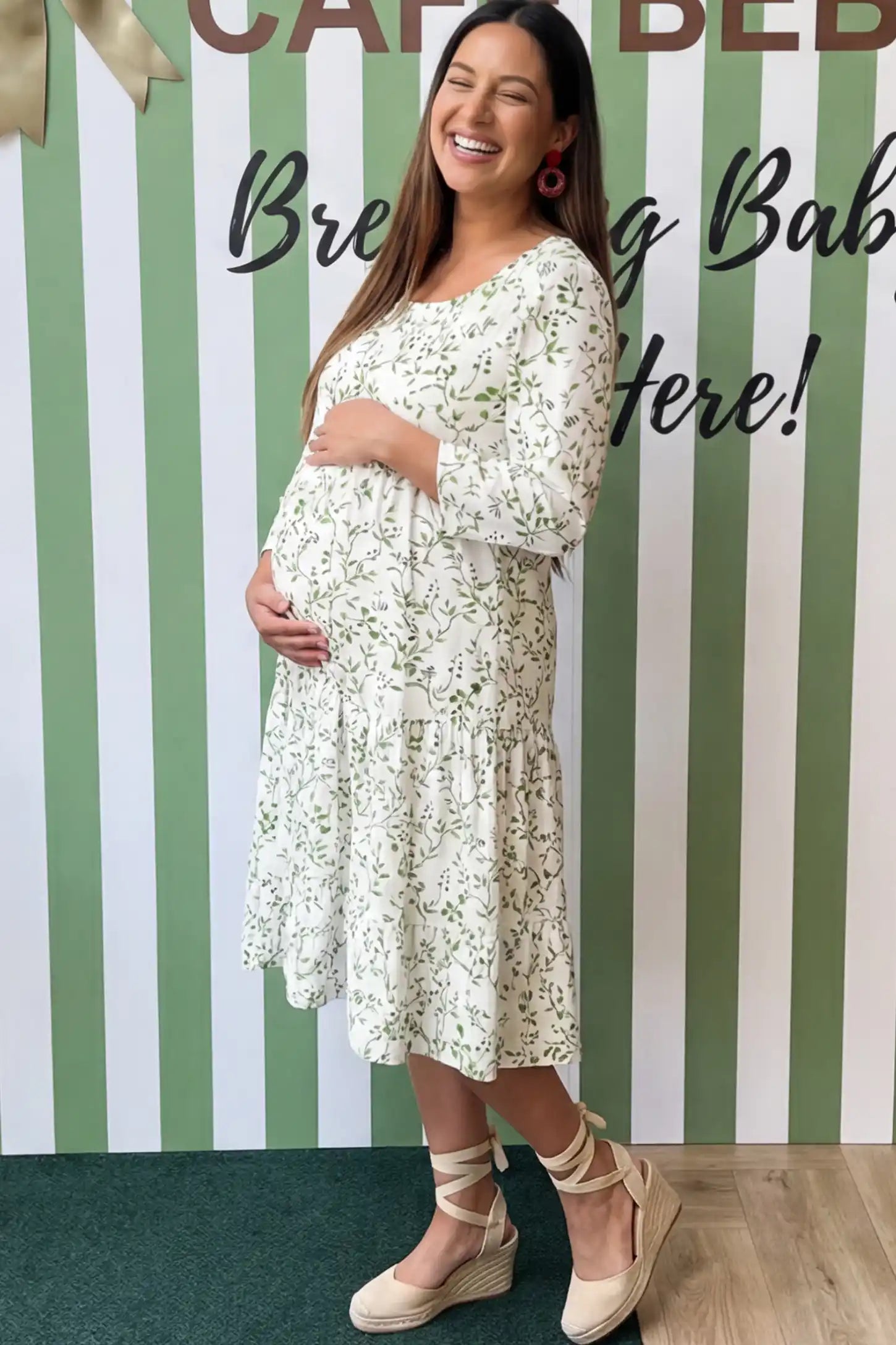 Floral Scoop Neck Tiered Maternity Midi Dress Floral Scoop Neck Tiered Midi Maternity Dress in Green featuring a sweet tiered skirt on a pregnant model.