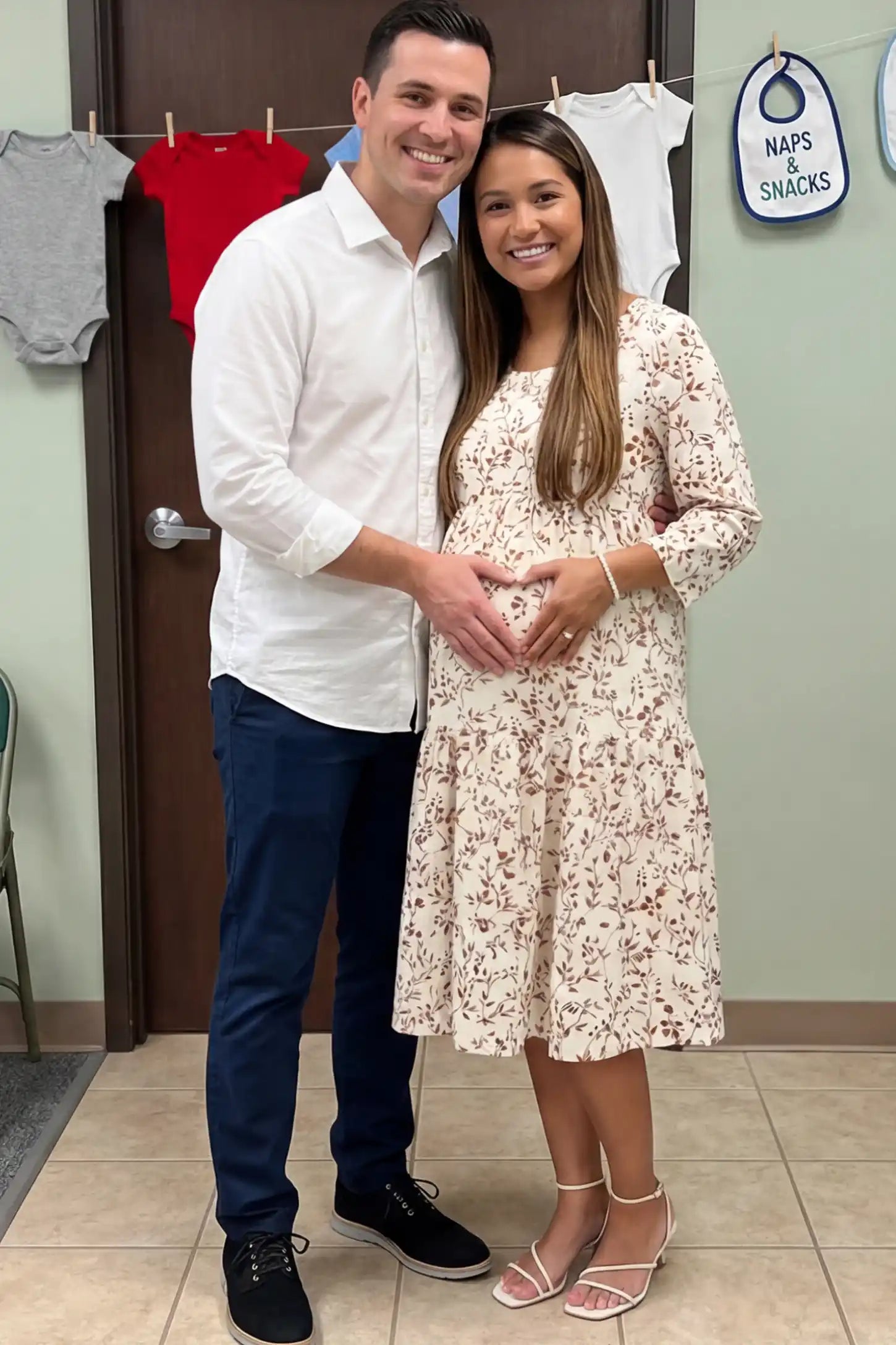 Floral Scoop Neck Tiered Maternity Midi Dress Floral Scoop Neck Tiered Midi Maternity Dress in Red featuring a sweet tiered skirt on a pregnant model posing with a partner.