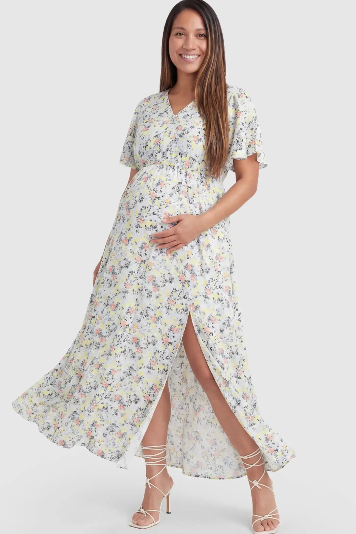 Floral V-Neck Side-Slit Maternity Maxi Dress Floral V-Neck Side-Slit Maternity Maxi Dress in white on a pregnant model.