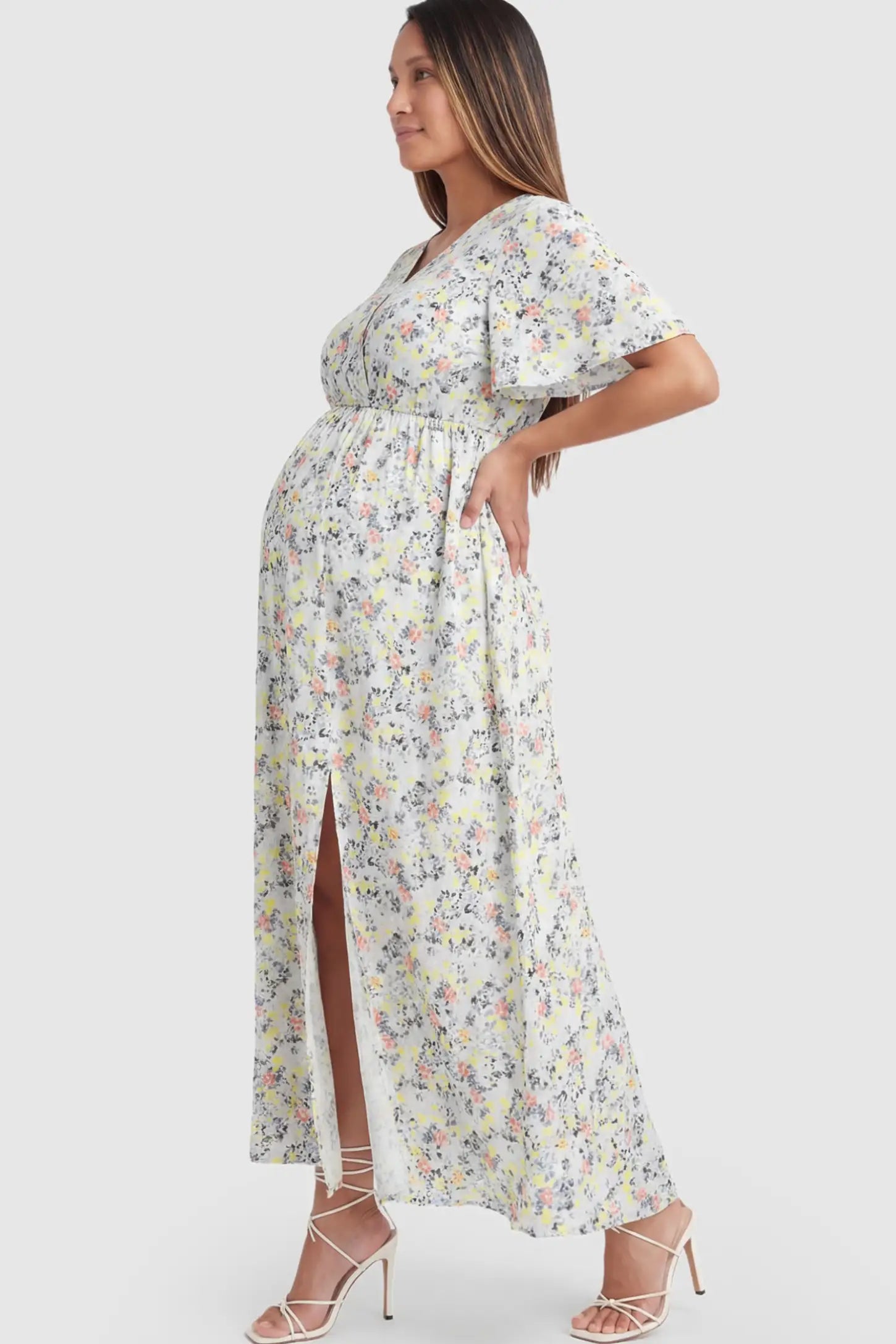Floral V-Neck Side-Slit Maternity Maxi Dress Floral V-Neck Side-Slit Maternity Maxi Dress in white on a pregnant model.