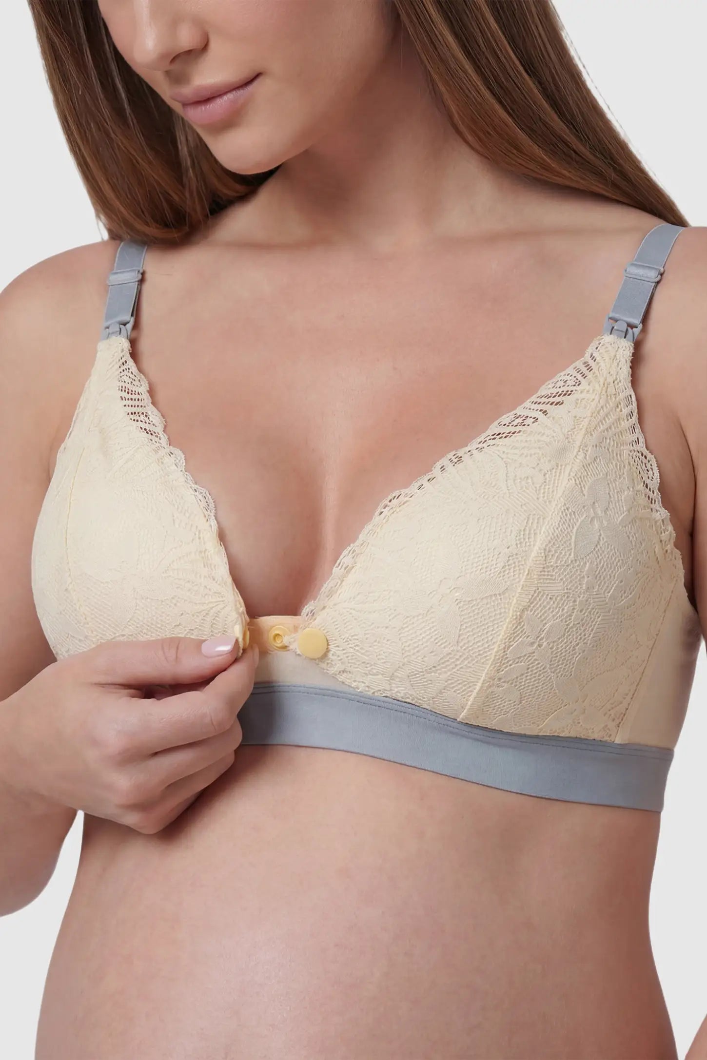 Floral Lace Front Button Maternity Nursing Bra Floral Lace Front Button Maternity Nursing Bra in Skin featuring a wide grey elastic underband on a pregnant model.