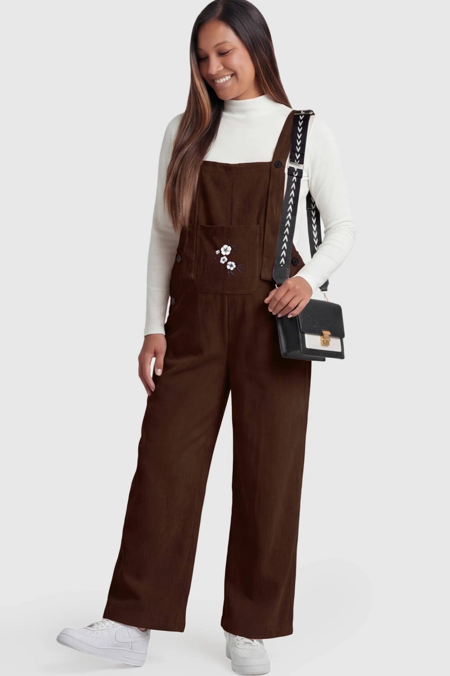 Adjustable Strap Wide-Leg Corduroy Maternity Overalls Floral Embroidered Wide-Leg Maternity Overalls in brown with adjustable straps on a pregnant model.