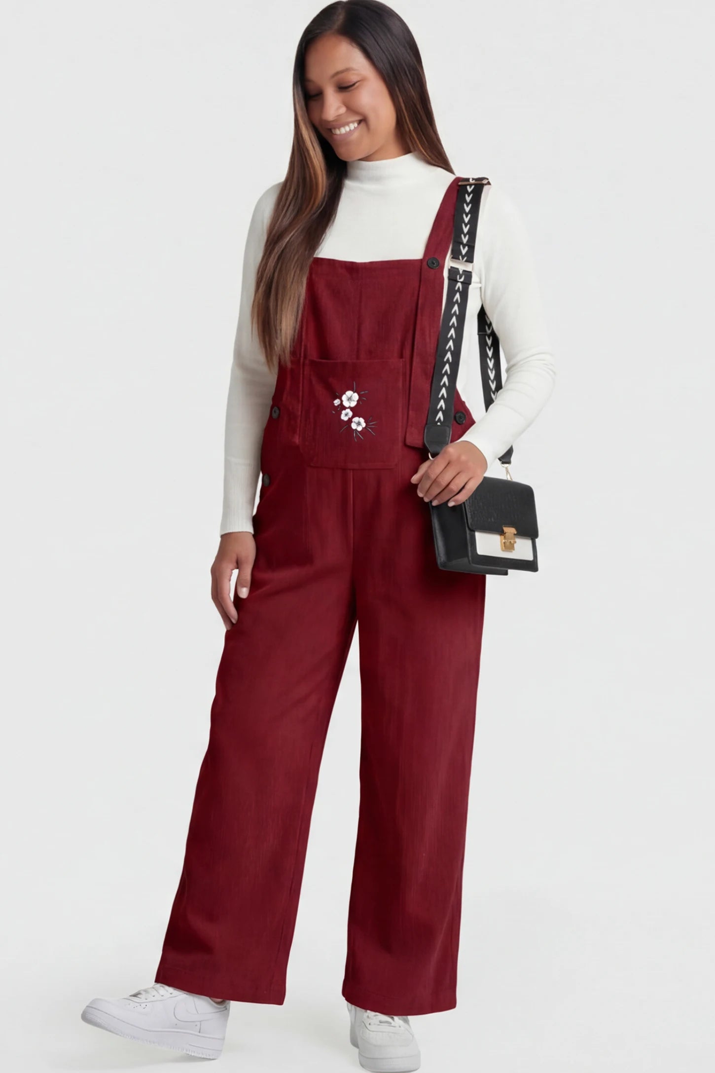 Adjustable Strap Wide-Leg Corduroy Maternity Overalls Floral Embroidered Wide-Leg Maternity Overalls in red with adjustable straps on a pregnant model.