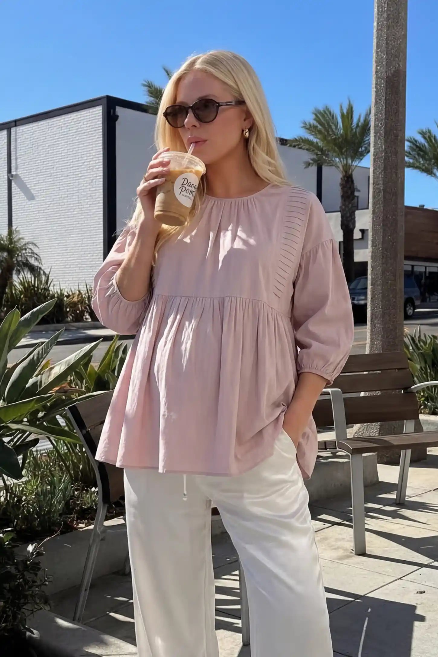 Peplum Round Neck Maternity Blouse Peplum round neck maternity blouse in pink with flowy peplum and 3/4 sleeves, front view on pregnant model