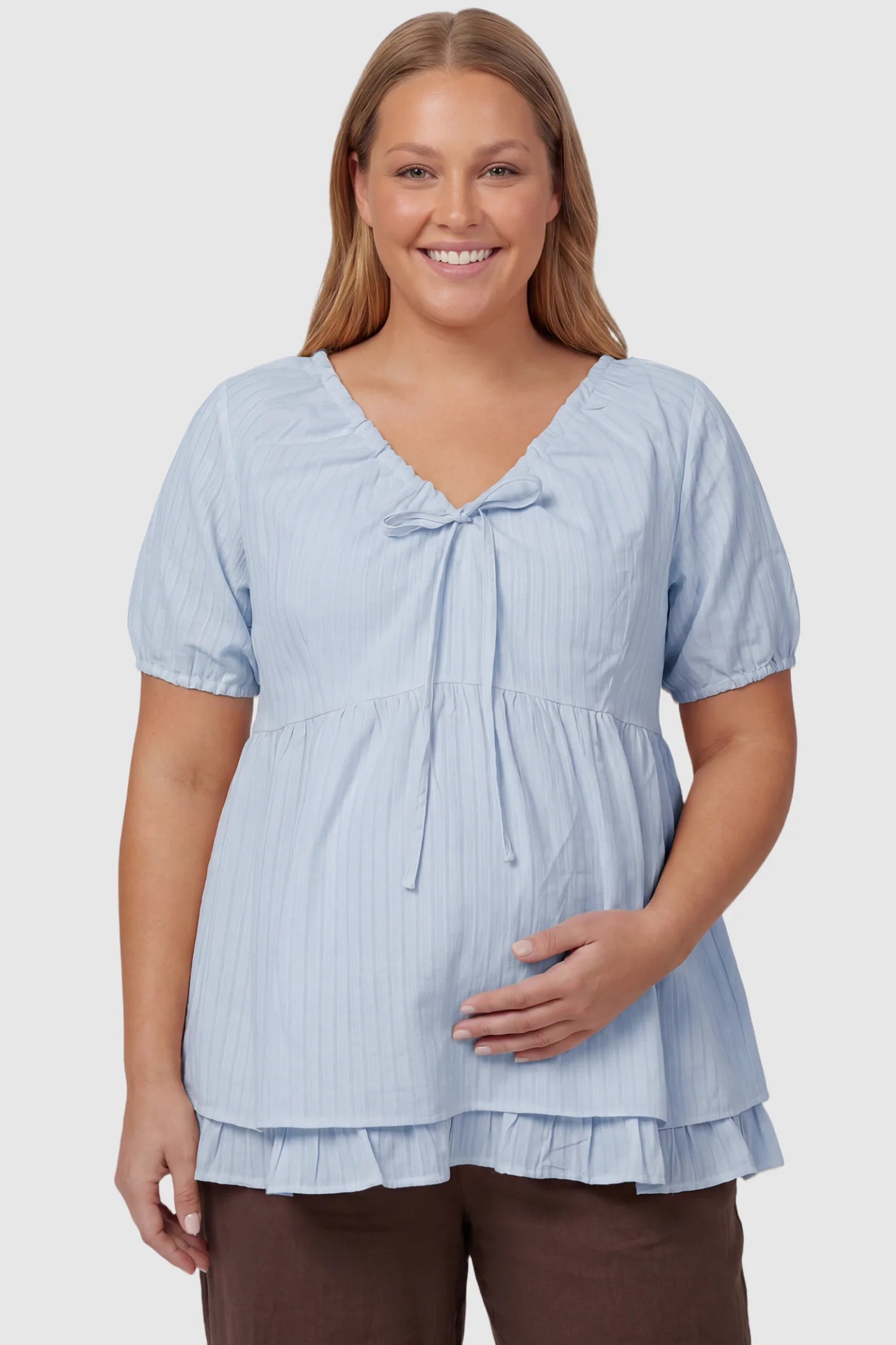 Drawstring V-Neck Peplum Maternity Top Drawstring V-neck peplum maternity top in blue with drawstring V-neck detail and puff sleeves, front view on plus-size model