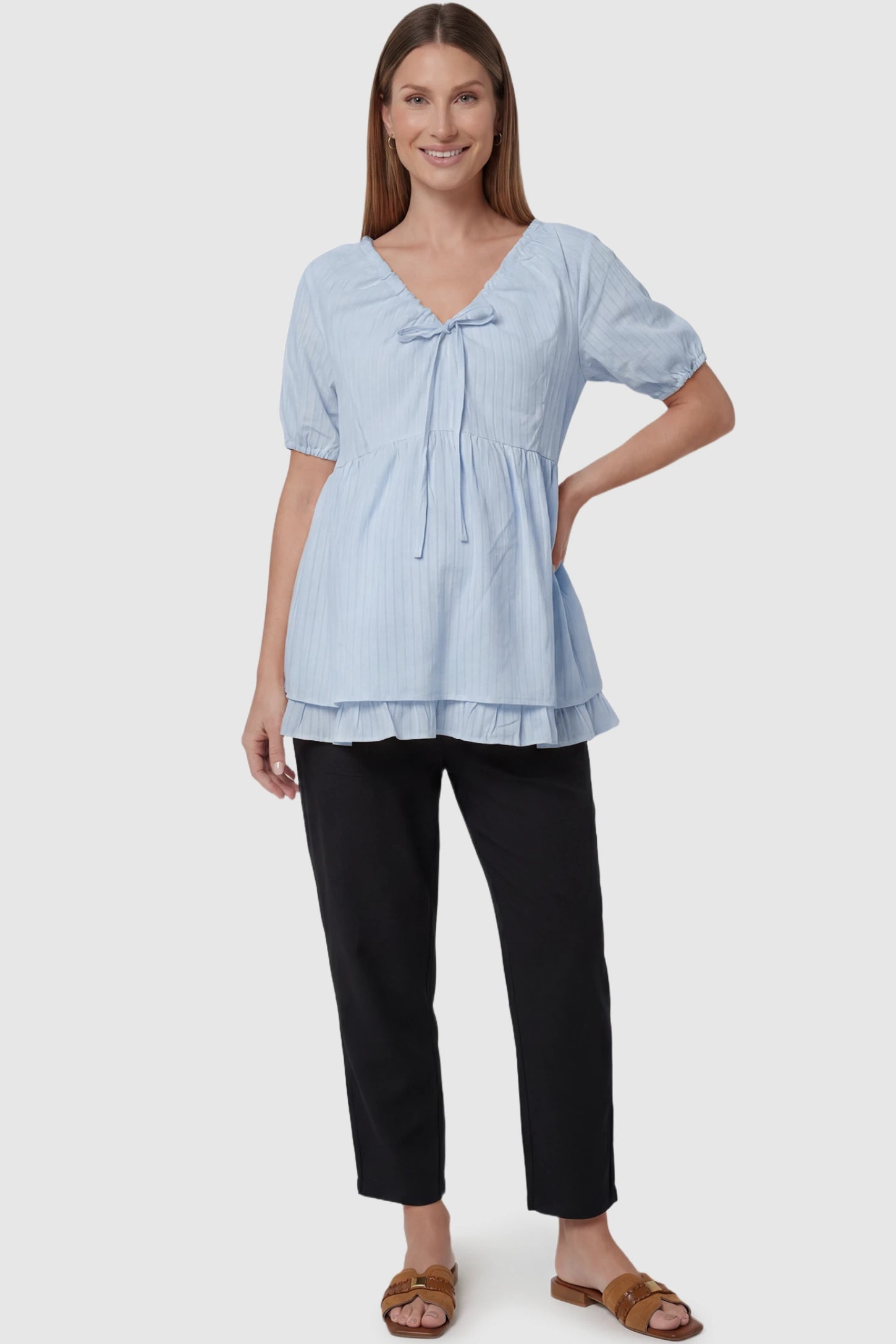 Drawstring V-Neck Peplum Maternity Top Drawstring V-neck peplum maternity top in blue with drawstring V-neck detail and puff sleeves, front view on pregnant model