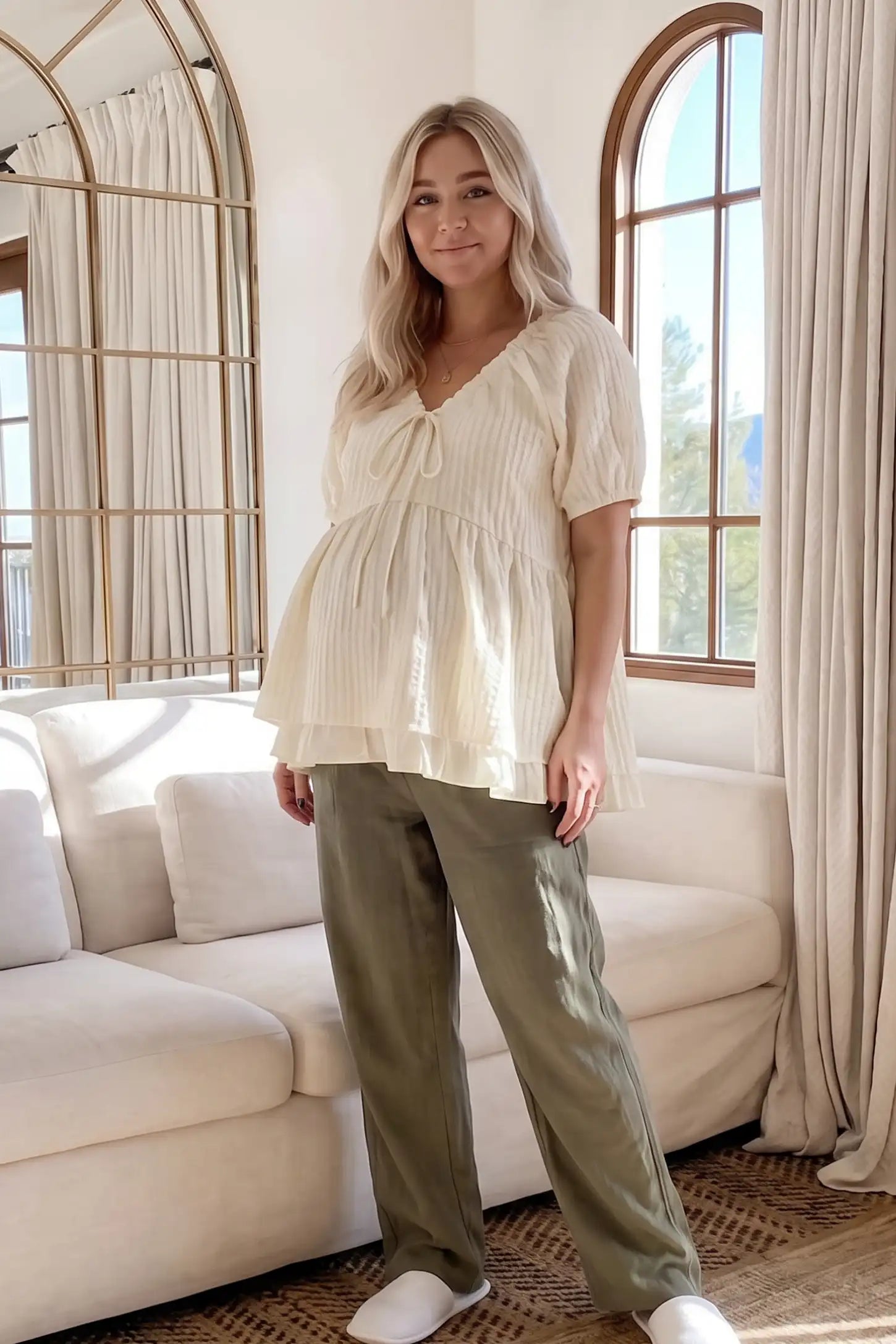 Drawstring V-Neck Peplum Maternity Top Drawstring V-neck peplum maternity top in cream with drawstring V-neck detail and puff sleeves, front view on pregnant model