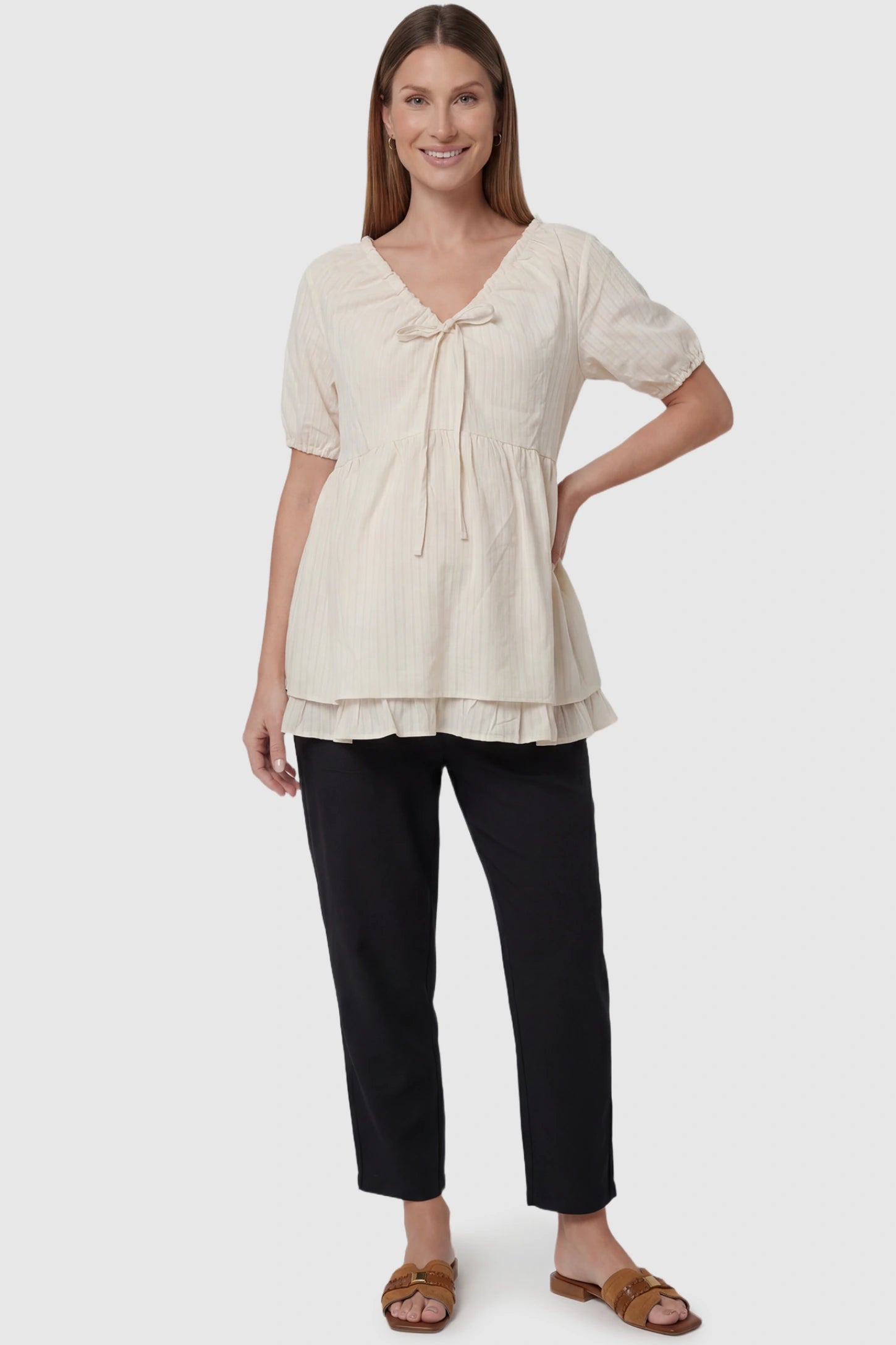Drawstring V-Neck Peplum Maternity Top Drawstring V-neck peplum maternity top in cream with drawstring V-neck detail and puff sleeves, front view on pregnant model