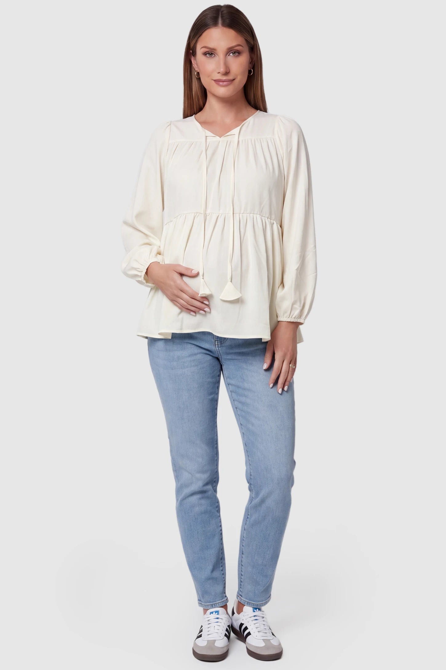 Tie-Front Tassel Long Sleeve Peplum Maternity Blouse Tie-front tassel long sleeve peplum maternity blouse in pale yellow with tie-front tassel detail, front view on pregnant model