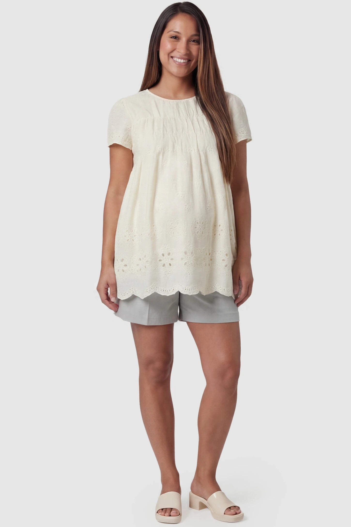 Floral Eyelet Round Neck Peplum Maternity Top Floral eyelet round neck peplum maternity top in pale yellow with delicate floral eyelet detail, front view on pregnant model