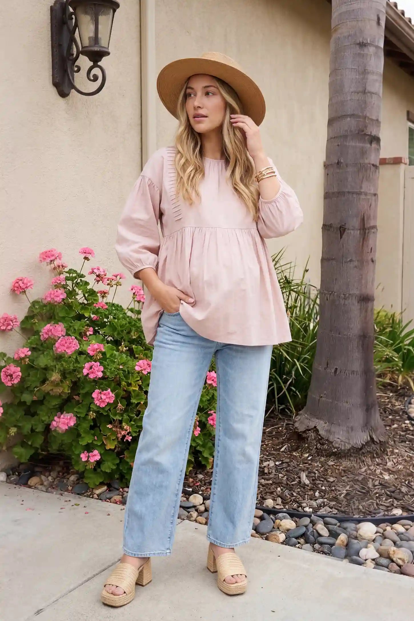 Peplum Round Neck Maternity Blouse Peplum round neck maternity blouse in pink with flowy peplum and 3/4 sleeves, front view on pregnant model