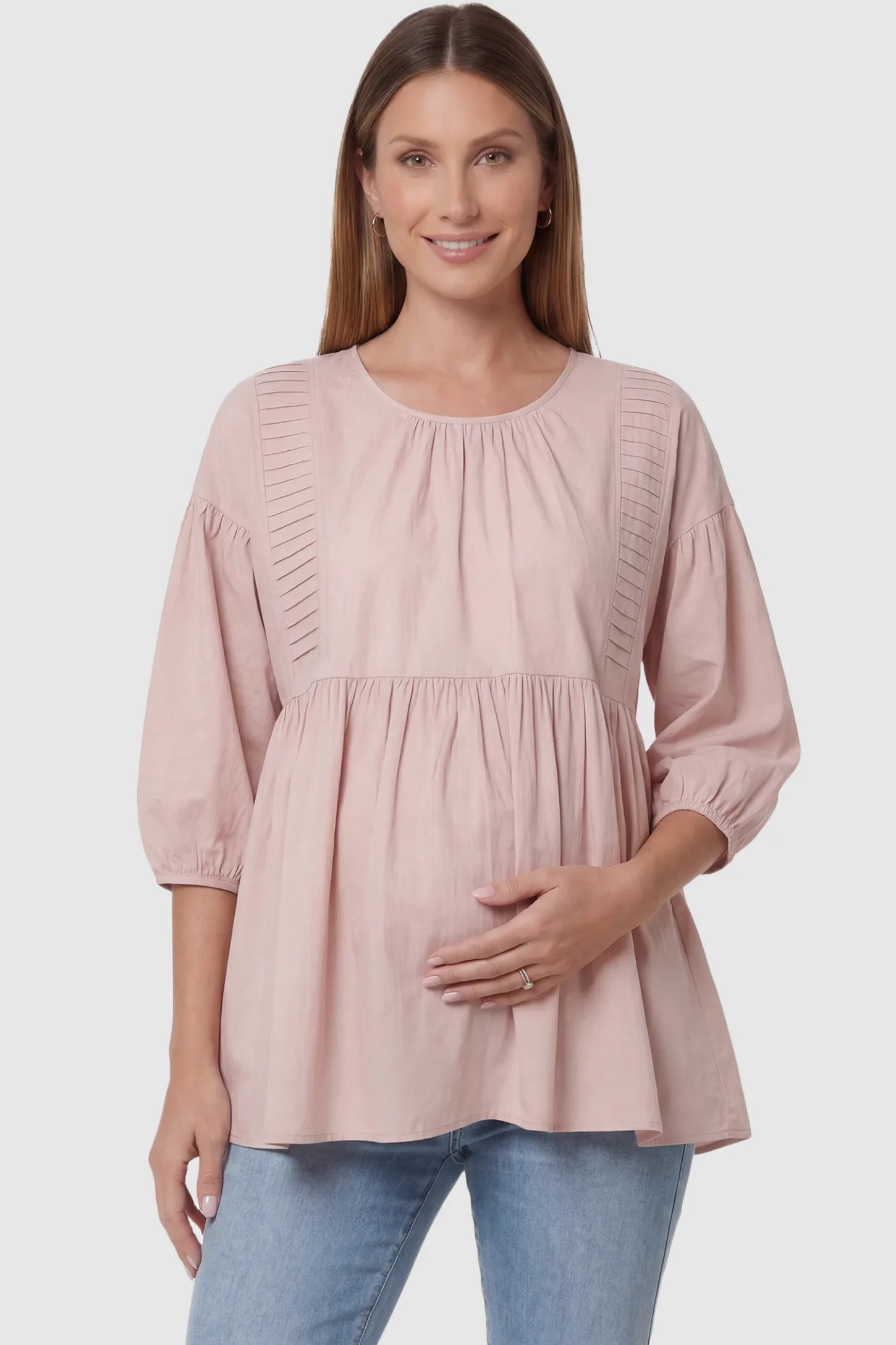 Peplum round neck maternity blouse in pink with flowy peplum and 3/4 sleeves, front view on pregnant model
