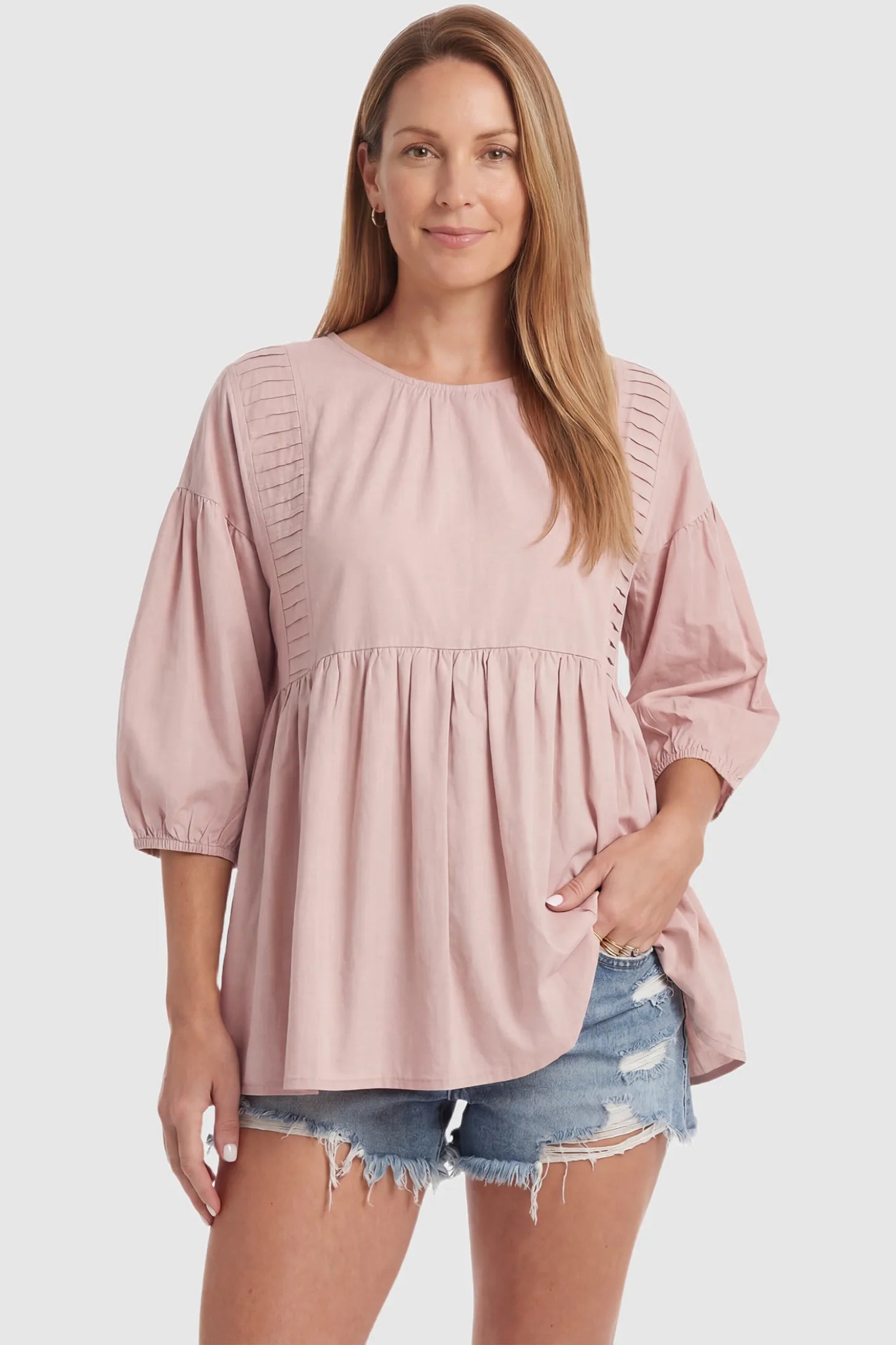 Peplum Round Neck Maternity Blouse Peplum round neck maternity blouse in pink with flowy peplum and 3/4 sleeves, front view on postpartum model