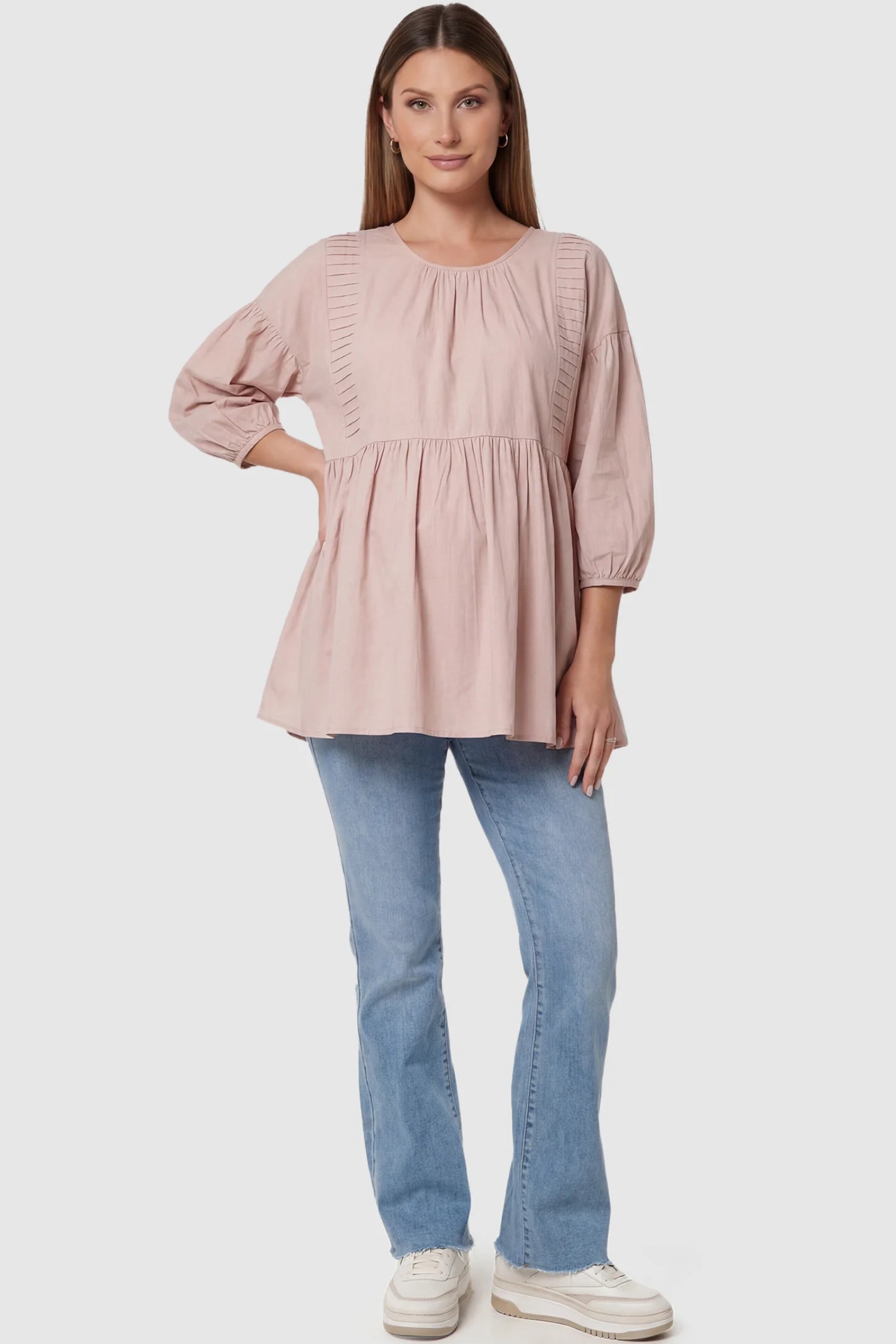 Peplum Round Neck Maternity Blouse Peplum round neck maternity blouse in pink with flowy peplum and 3/4 sleeves, front view on pregnant model