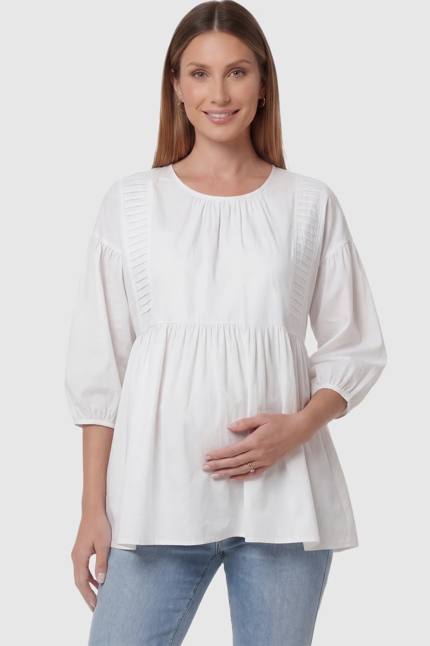 Peplum Round Neck Maternity Blouse Peplum round neck maternity blouse in white with flowy peplum and 3/4 sleeves, front view on pregnant model
