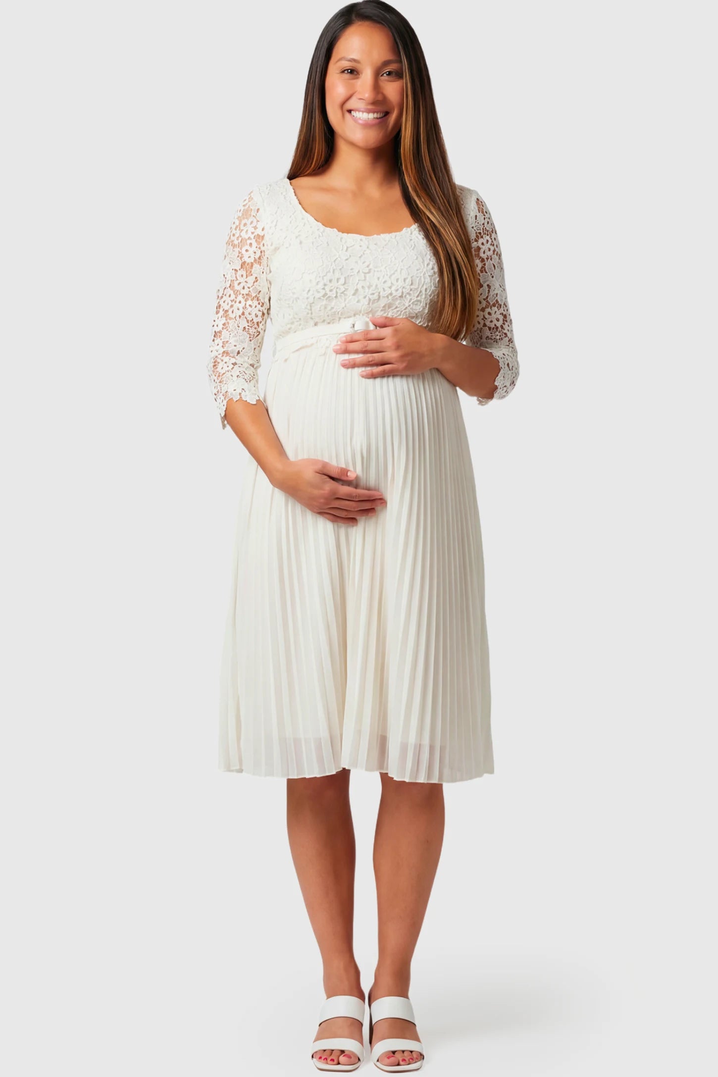 Pleated 3/4 Lace Sleeve Maternity Midi Dress in white featuring scoop neckline, lace sleeves, empire waist, and flowy pleated skirt on pregnant model.