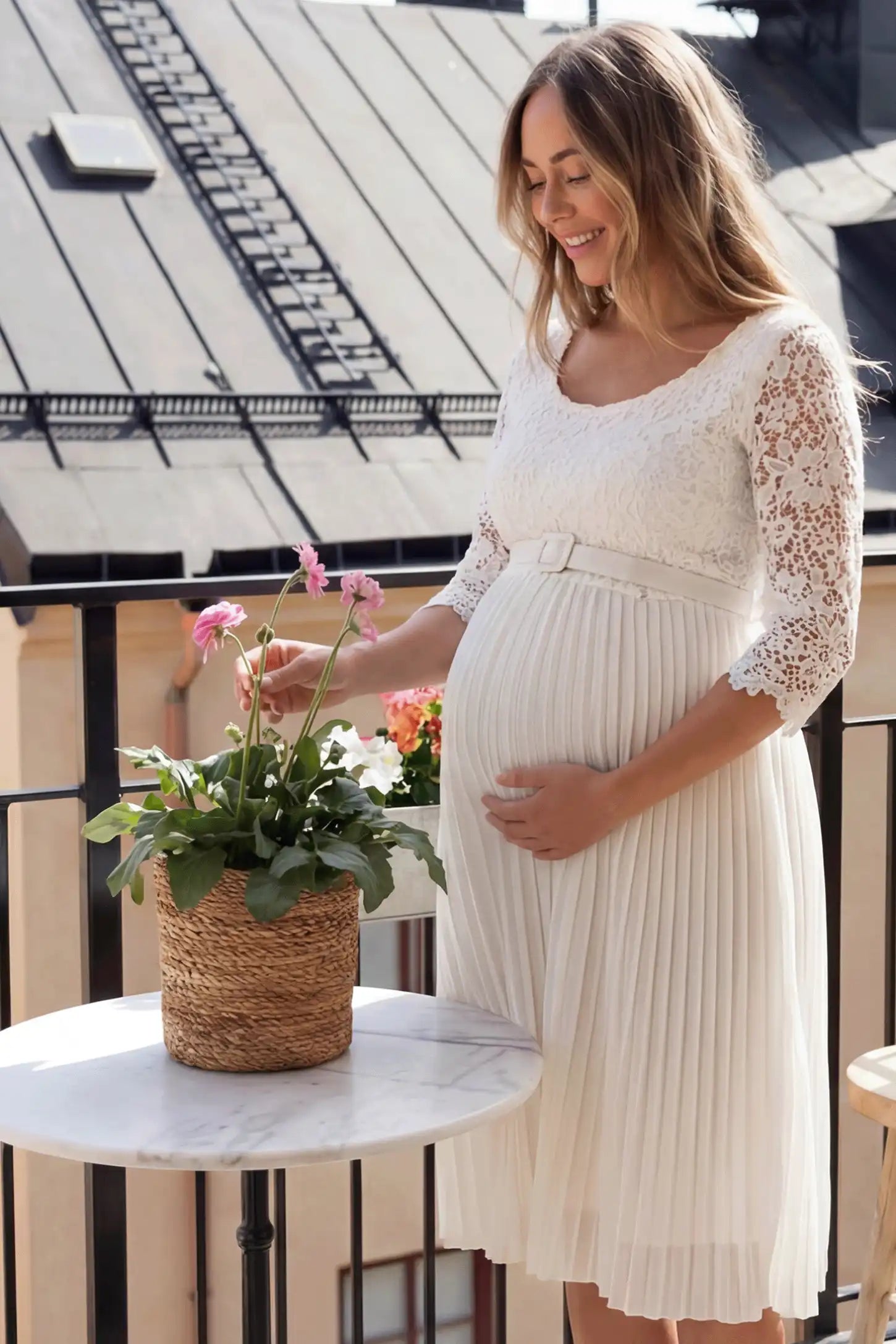 Pleated 3/4 Lace Sleeve Maternity Midi Dress in white featuring scoop neckline, lace sleeves, empire waist, and flowy pleated skirt on pregnant model.