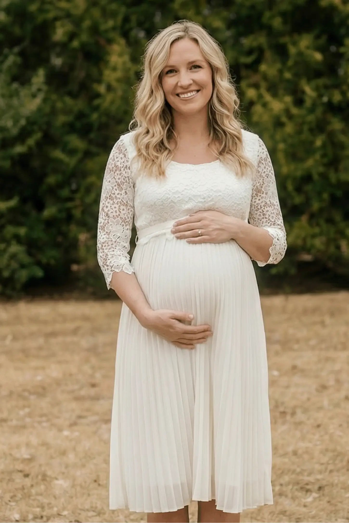 Pleated 3/4 Lace Sleeve Maternity Midi Dress Pleated 3/4 Lace Sleeve Maternity Midi Dress in white featuring scoop neckline, lace sleeves, empire waist, and flowy pleated skirt on pregnant model.