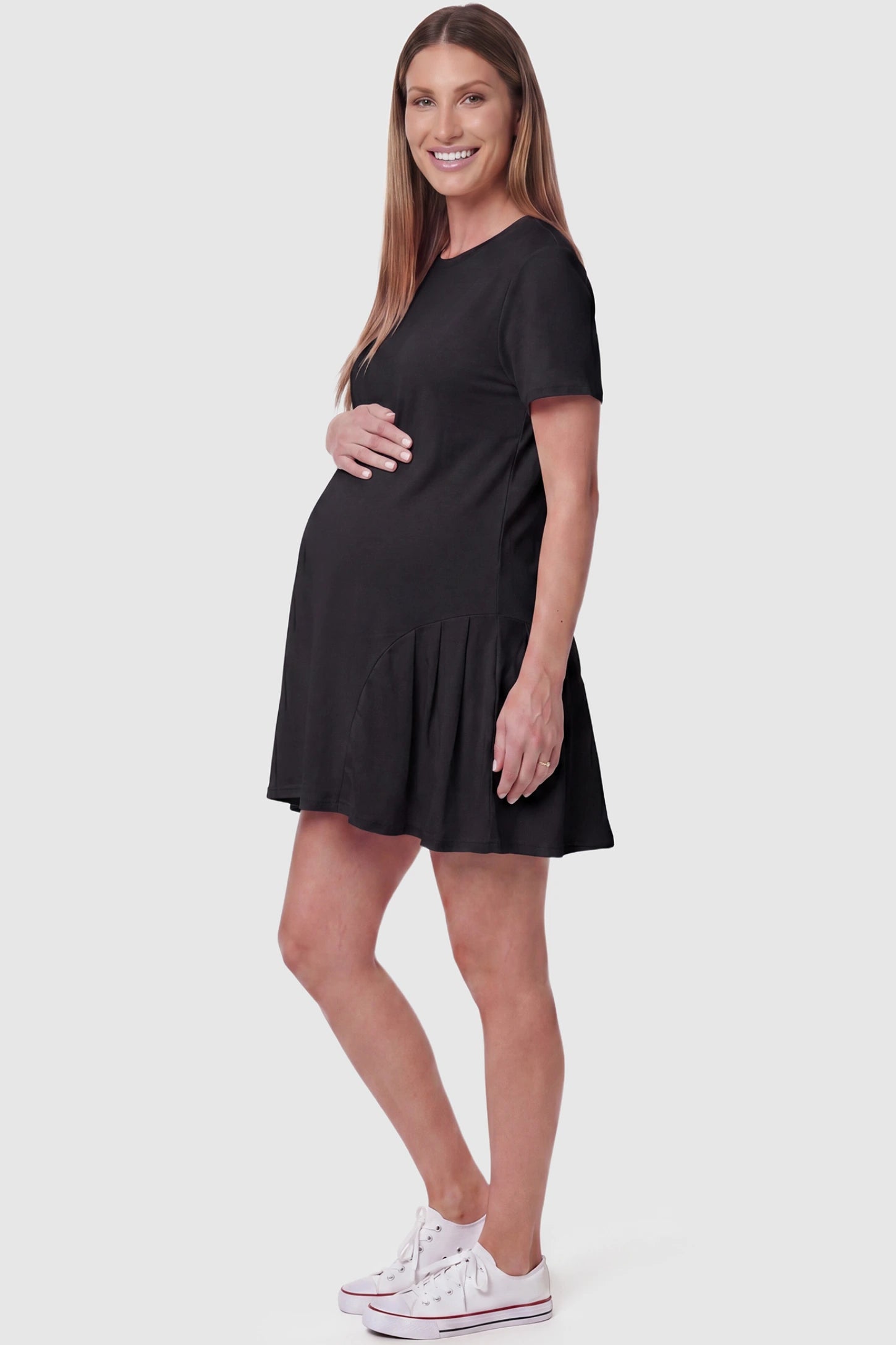Pleated Hem A-line Maternity Short Dress Pleated hem A-line maternity short dress in black with short sleeves, side view on pregnant model