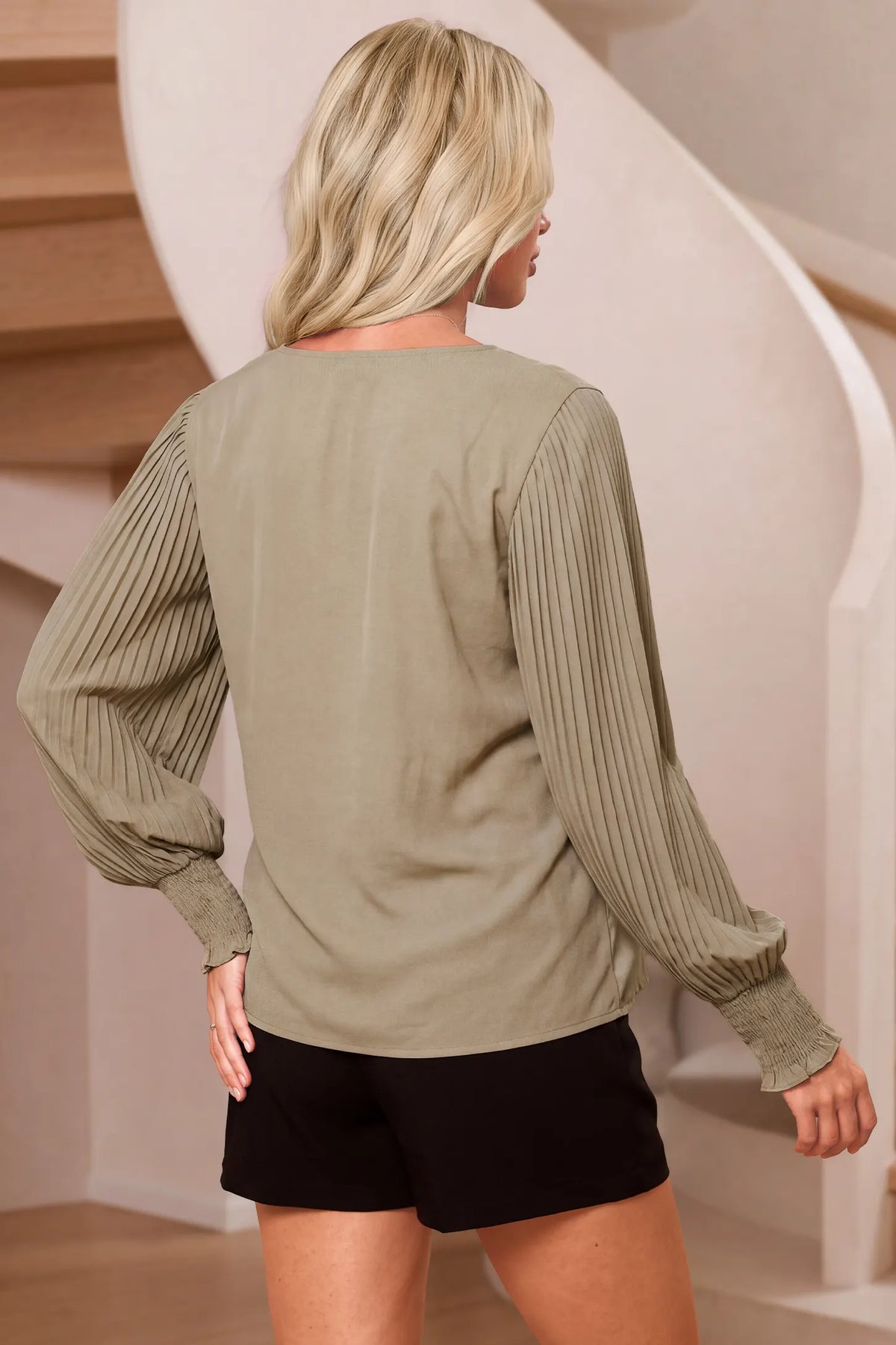 Pleated Sleeve V-Neck Maternity Blouse Pleated Sleeve V-Neck Maternity Blouse in Khaki featuring a regular silhouette and long pleated sleeves with full back coverage on a model standing near stairs, back view.