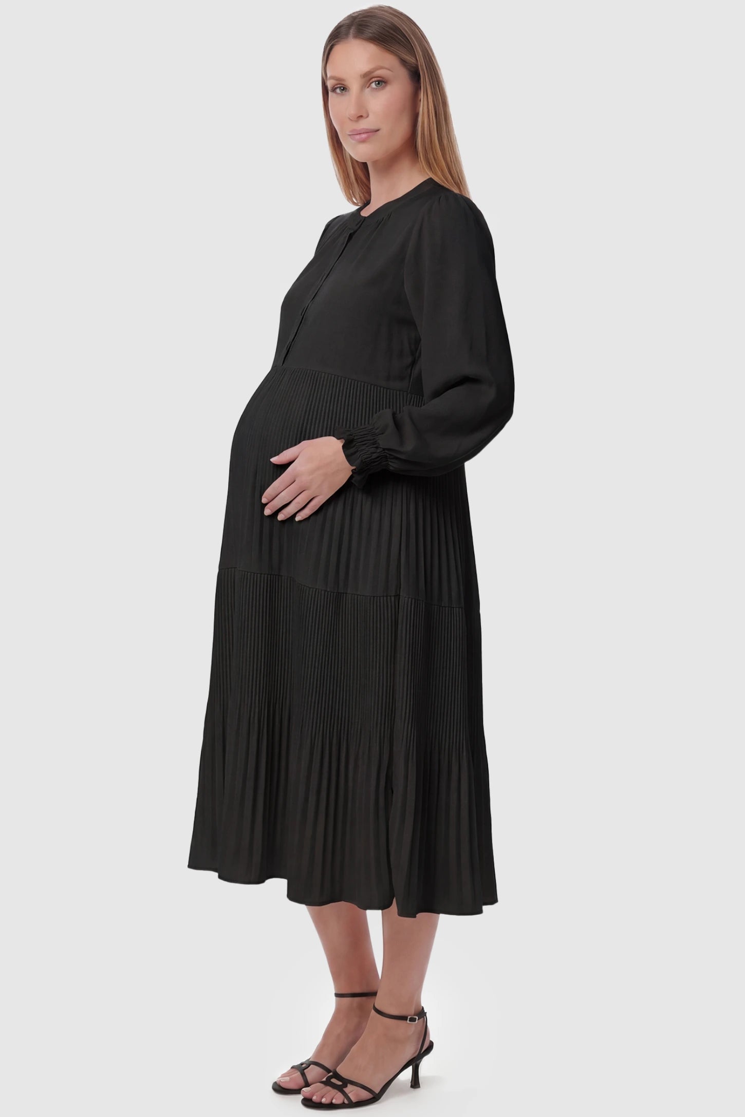 Button-Up Neck Pleated Tiered Maternity Midi Dress Button-up neck pleated tiered maternity midi dress in black with soft pleated design, side view on pregnant model