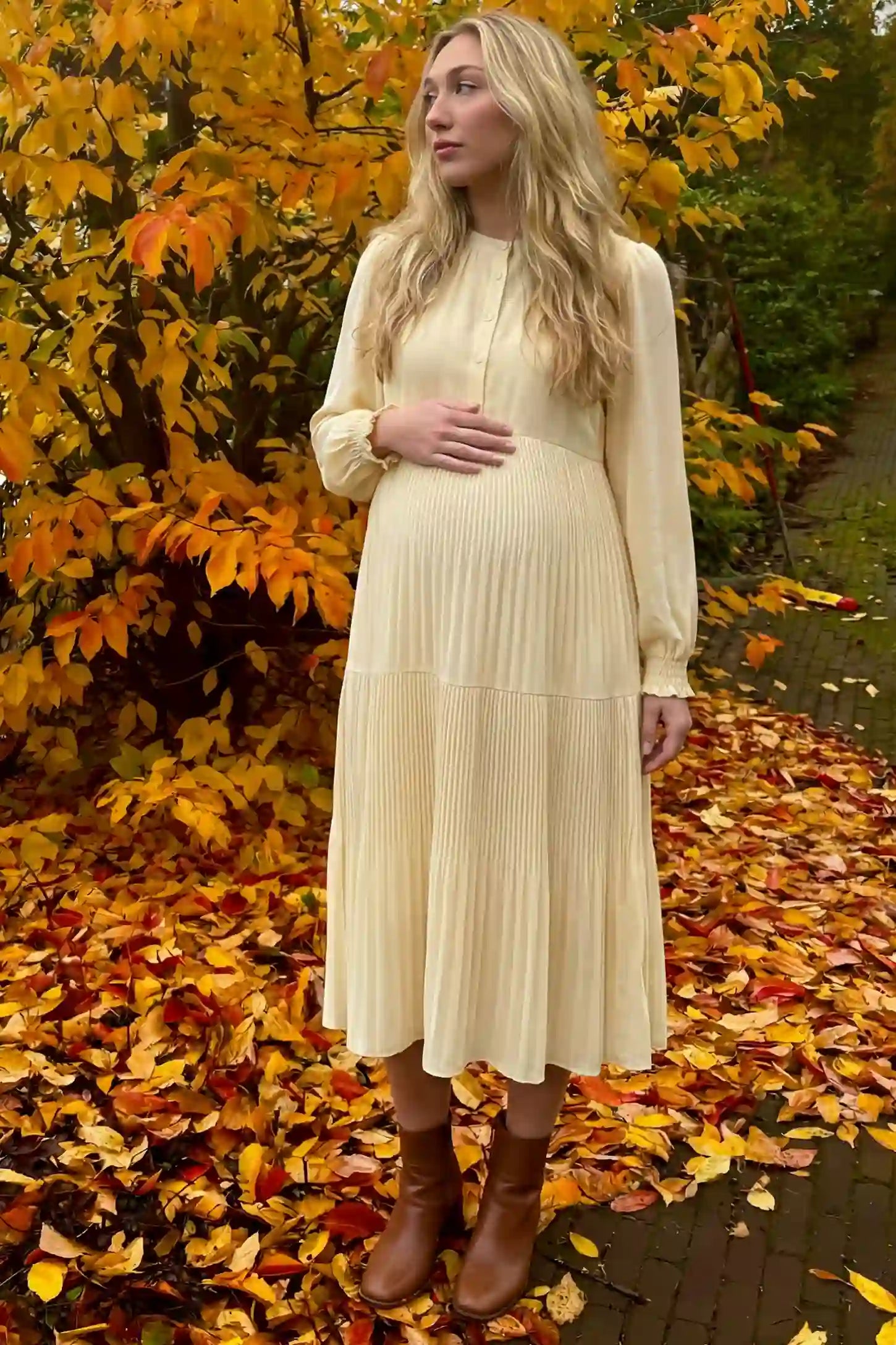 Button-Up Neck Pleated Tiered Maternity Midi Dress Button-up neck pleated tiered maternity midi dress in pale yellow with soft pleated design, front view on pregnant model