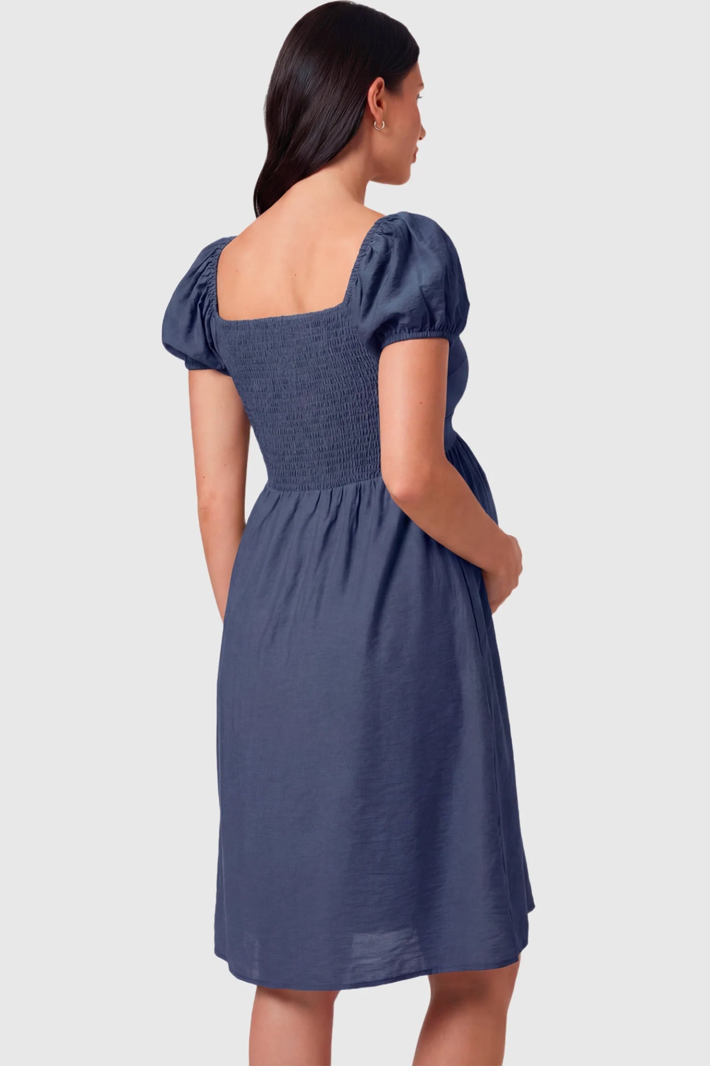 Short Puff Sleeve Empire Waist Maternity & Nursing Midi Dress Short Puff Sleeve Empire Waist Maternity & Nursing Midi Dress in navy blue featuring a smocked bodice, and A-line silhouette on a pregnant model.